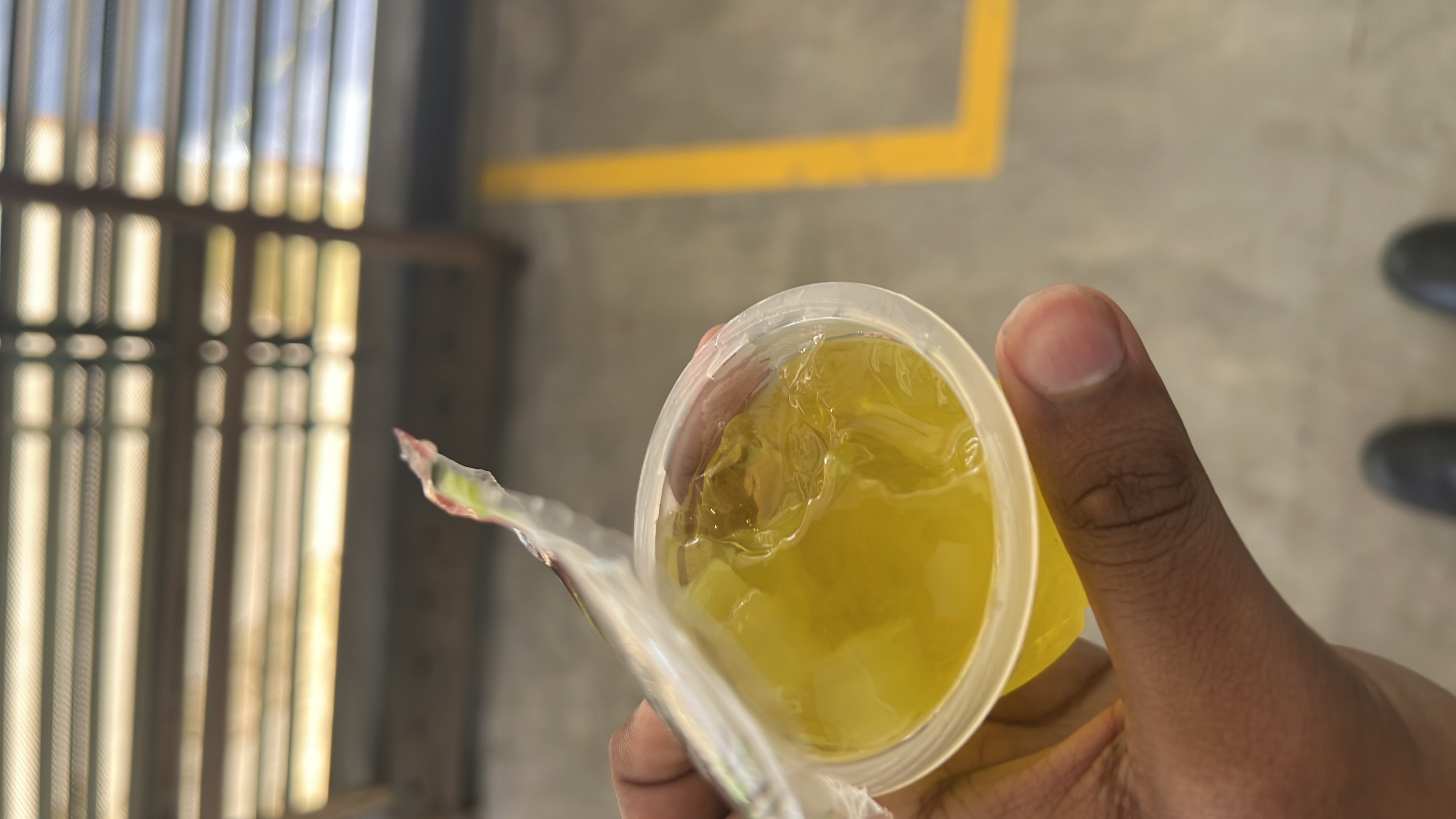 A small cup of yellow gelatin dessert, low in calories and fats, primarily composed of carbohydrates.