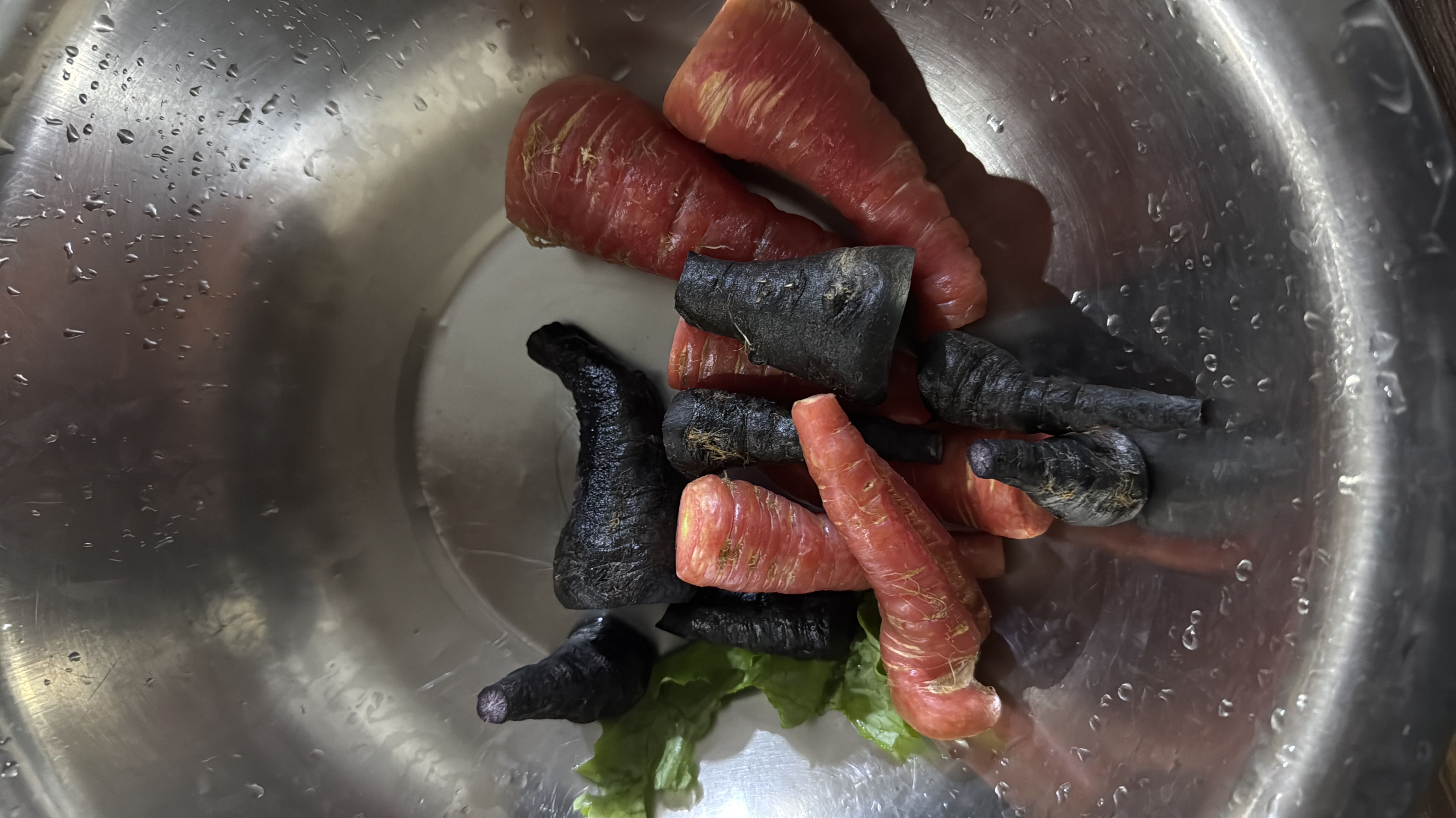 The image shows a mix of purple and red carrots in a metal bowl, which are low-calorie, nutrient-rich vegetables.