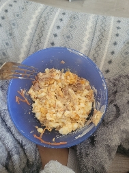 A bowl of scrambled eggs mixed with cheese and tuna, providing a balanced mix of protein, fats, and carbs.