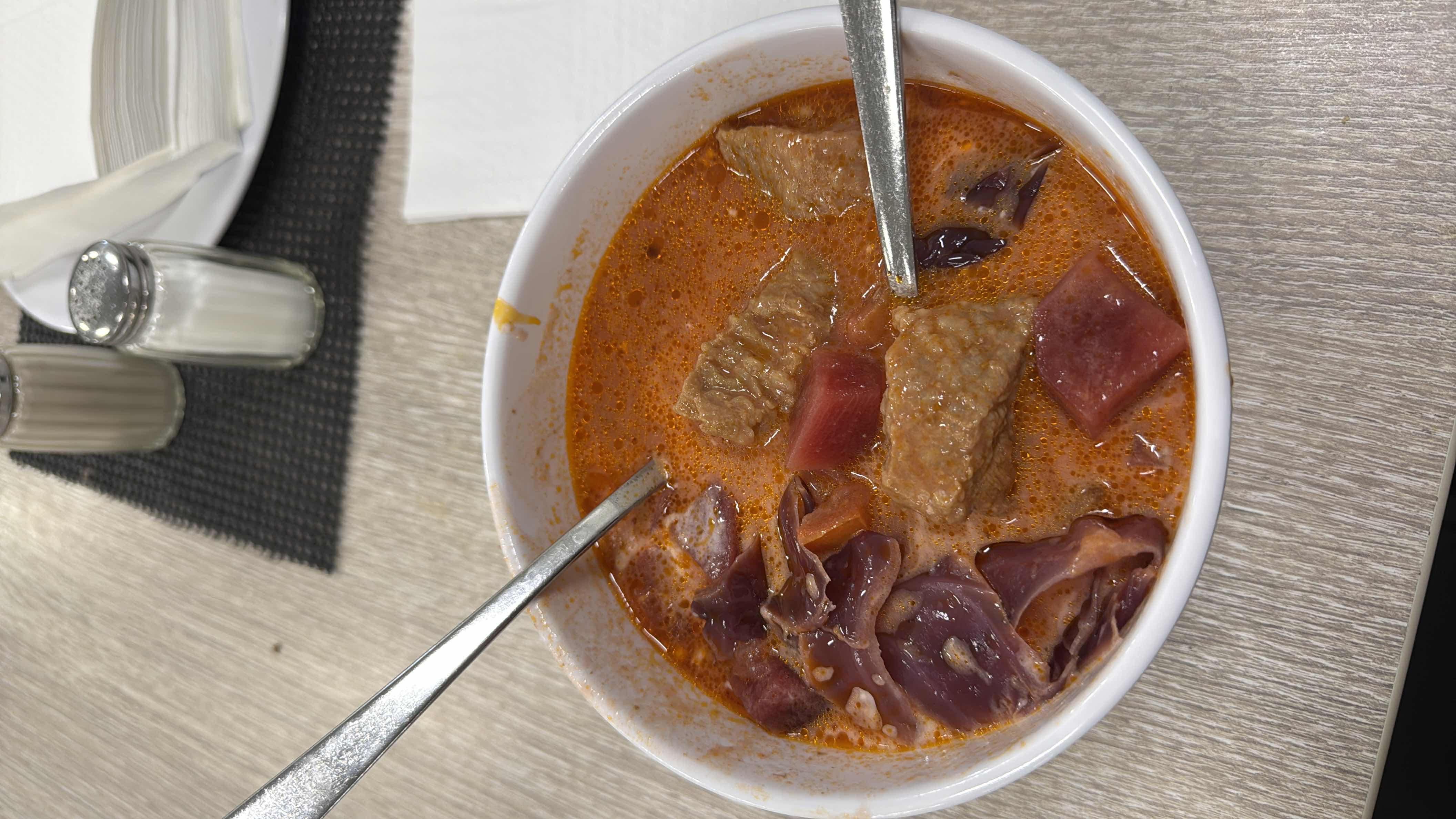 A hearty soup with beef, red cabbage, tomato, and a flavorful broth, providing a balanced mix of protein, carbs, and fats.