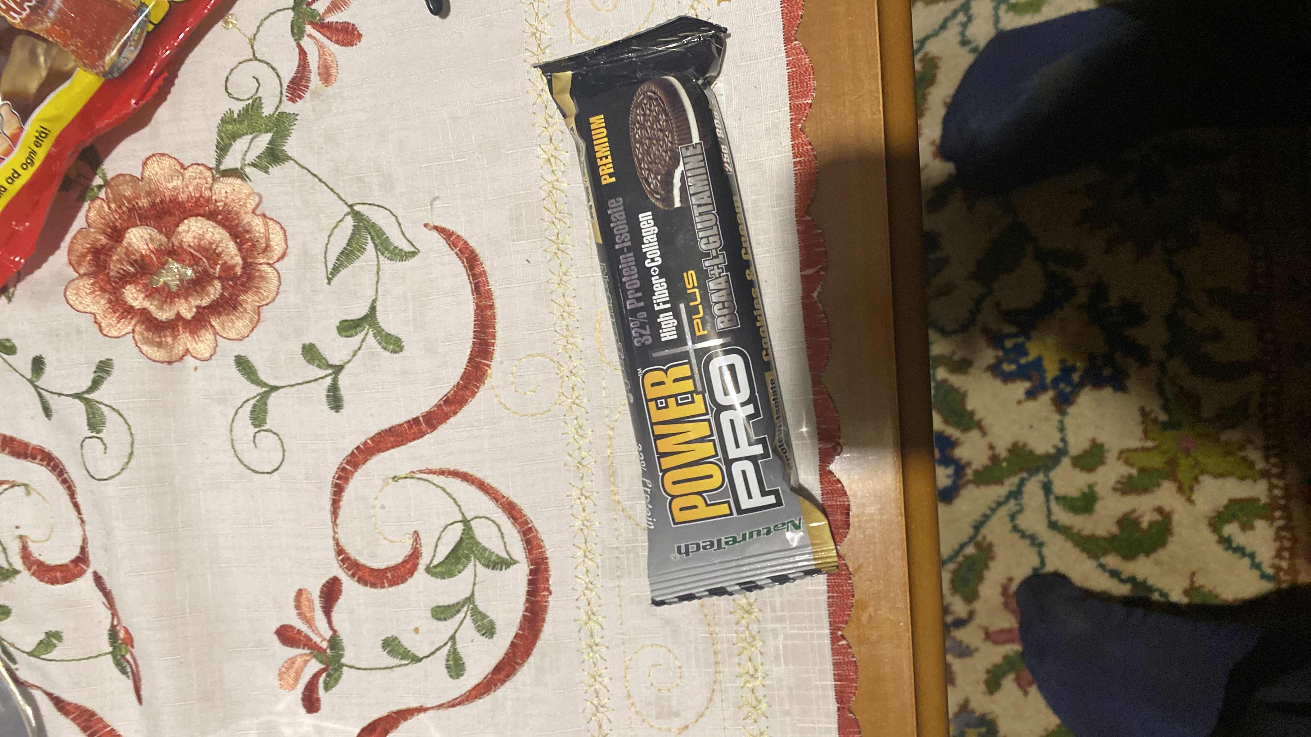 A high-protein snack bar with 32% protein isolate, high fiber, collagen, and BCAA+L-Glutamine, featuring a cookies and cream flavor.