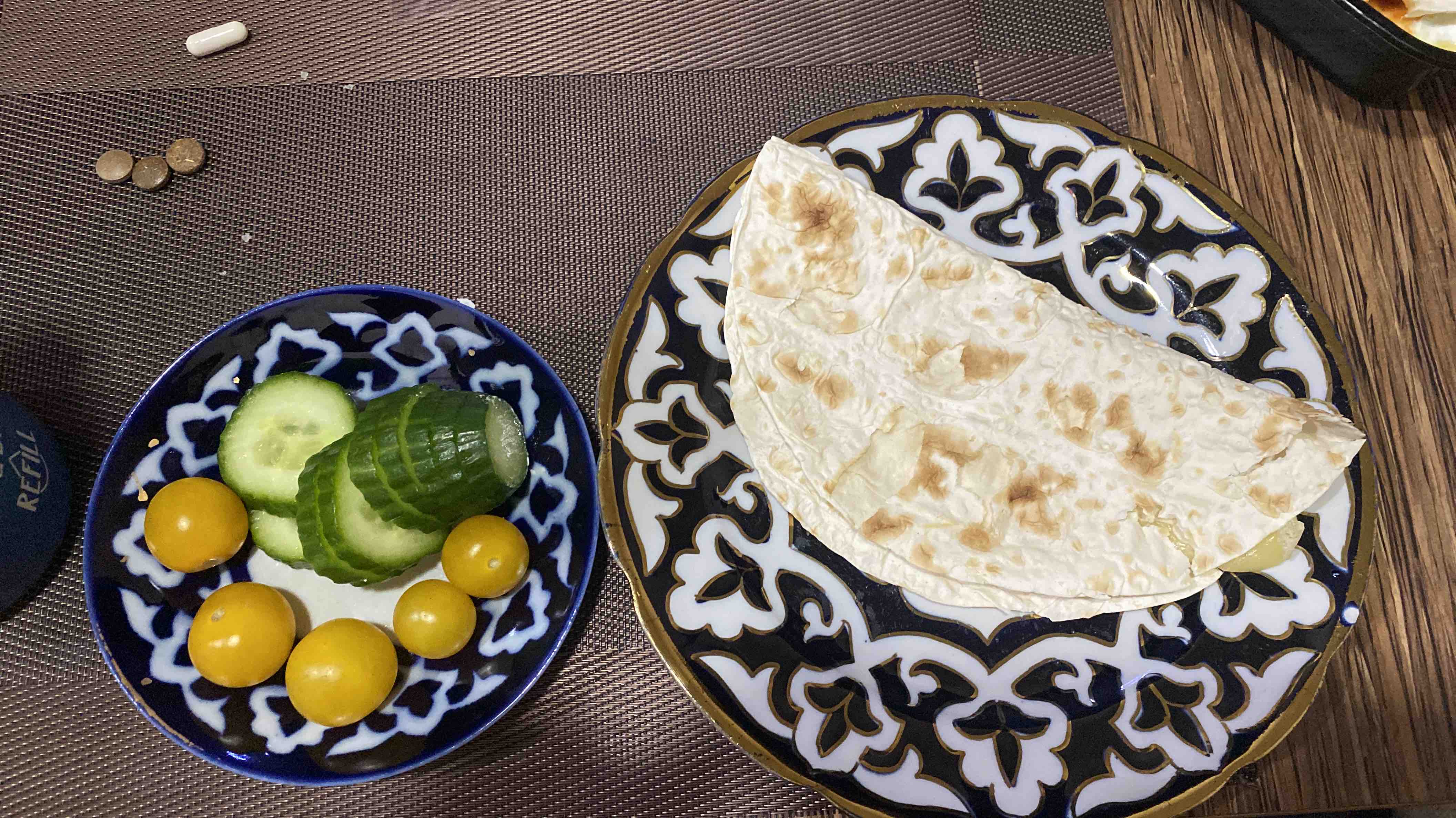 A meal consisting of flatbread, cucumber slices, yellow cherry tomatoes, and low-fat cheese, providing a balanced mix of carbohydrates, fats, and proteins.