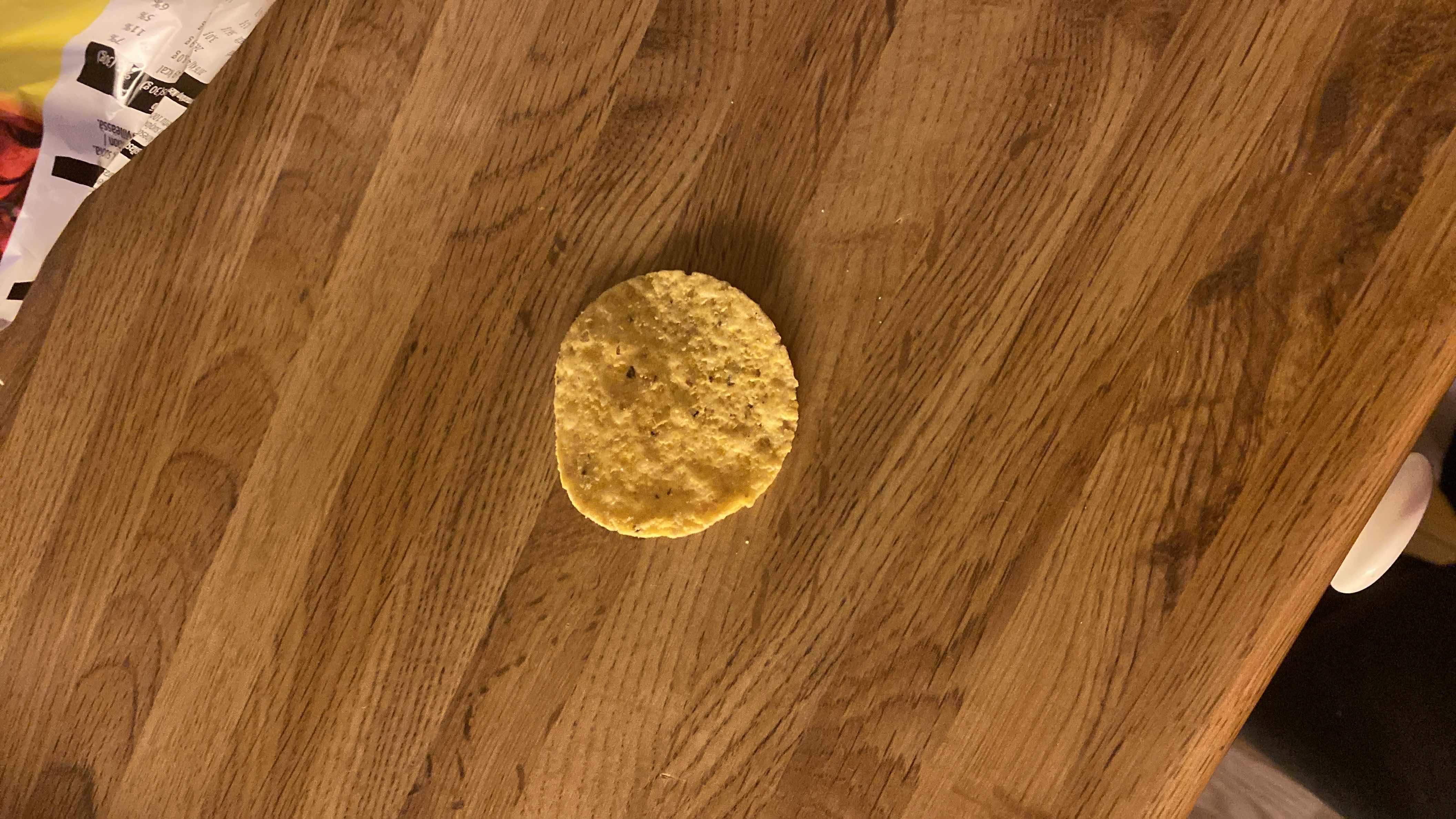 A single corn chip, likely a snack item, with minimal nutritional content.