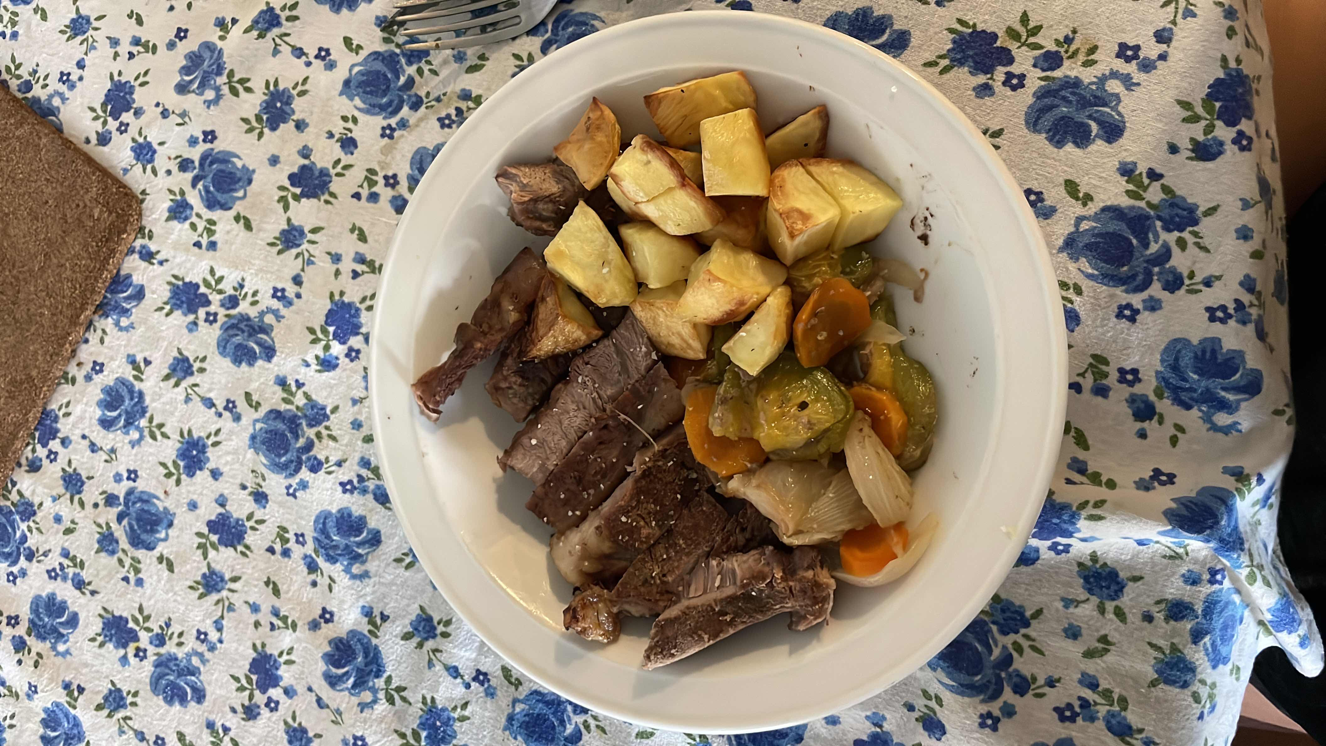 A balanced meal consisting of beef steak, roasted potatoes, and mixed vegetables, providing a good mix of protein, carbs, and fats.