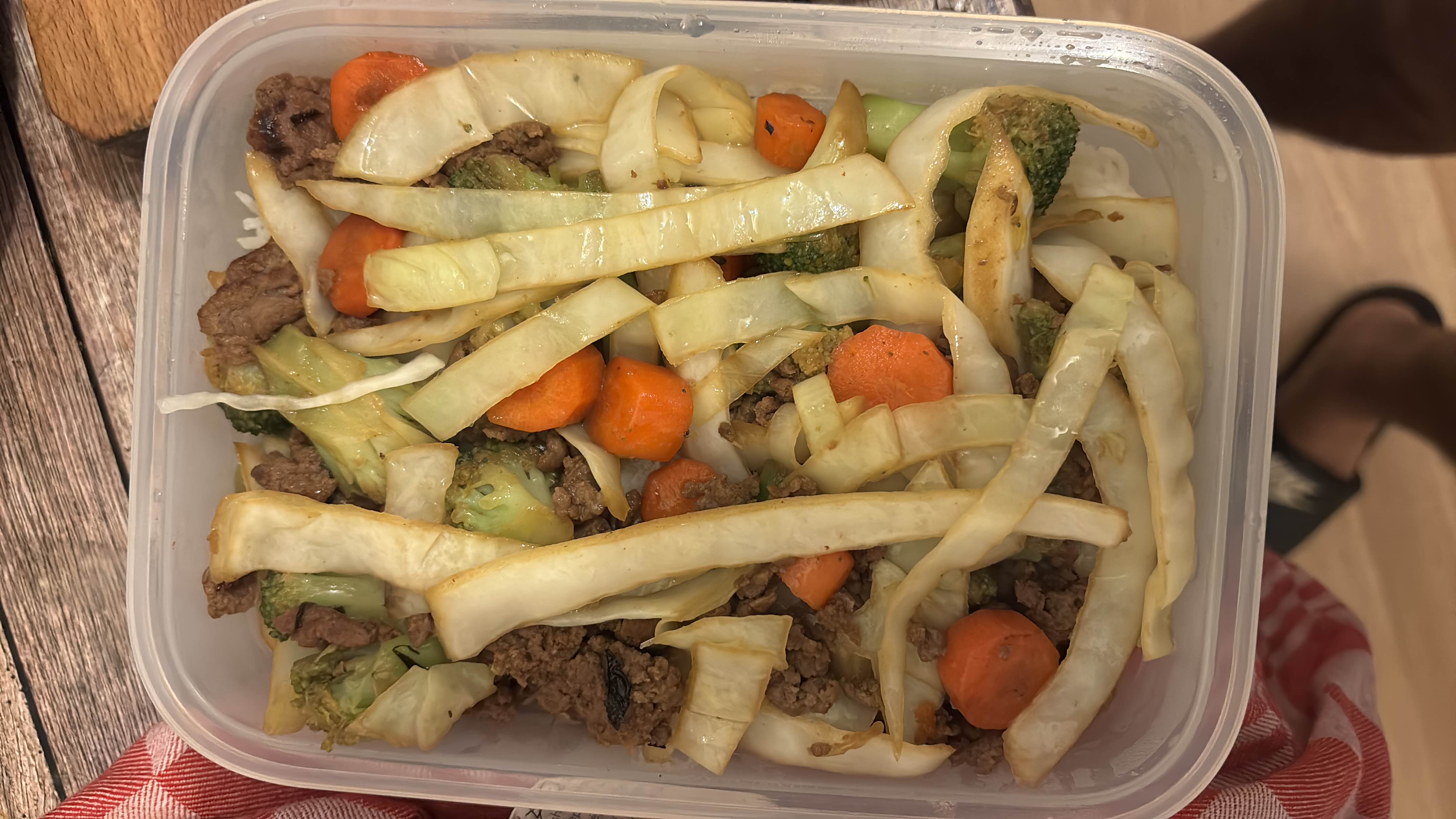 A healthy meal consisting of stir-fried cabbage, carrots, broccoli, and ground beef, providing a balanced mix of protein, carbs, and fats.