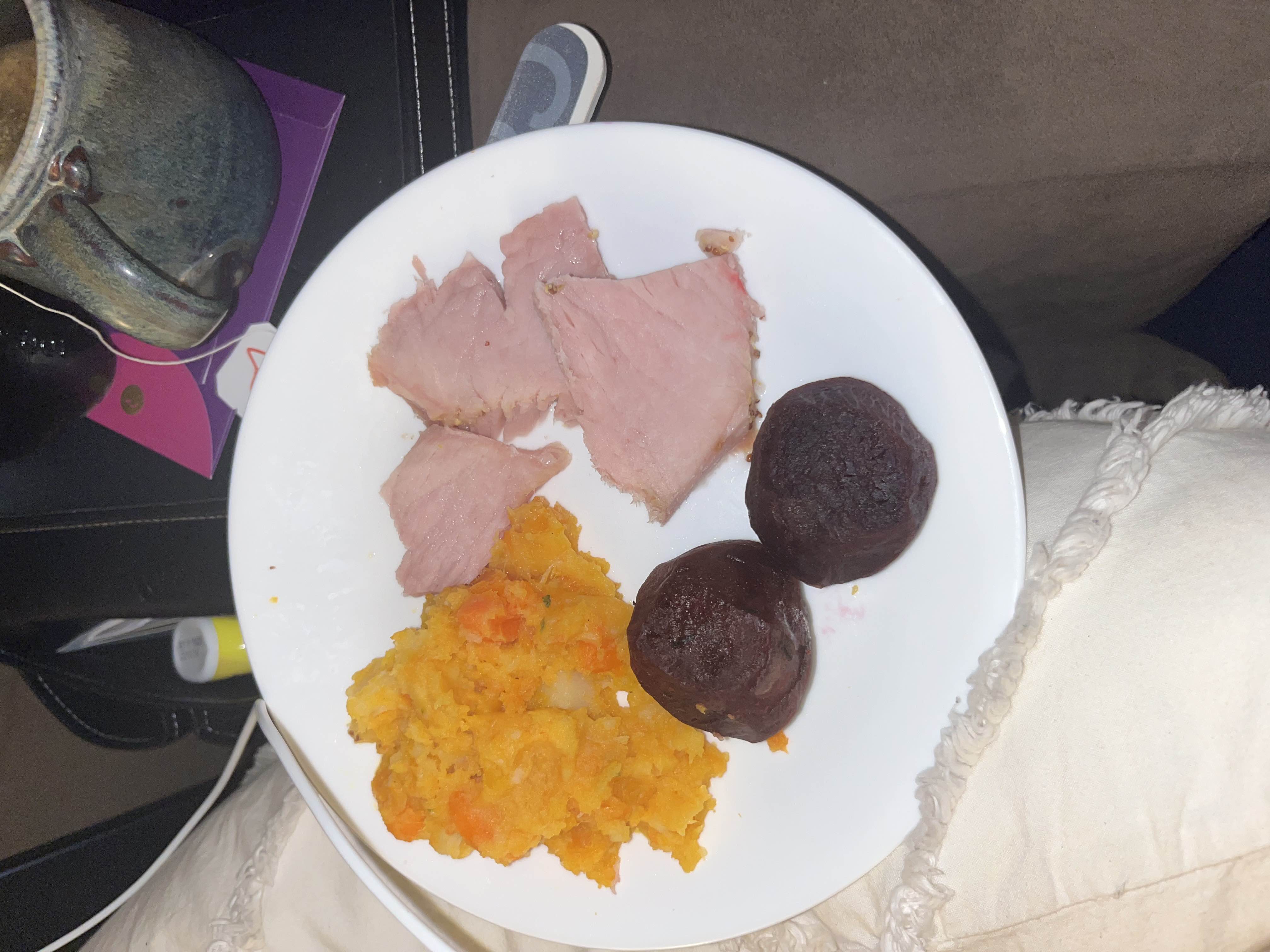A balanced meal consisting of sliced ham, mashed root vegetables, and cooked beets, providing a good mix of protein, carbohydrates, and essential nutrients.