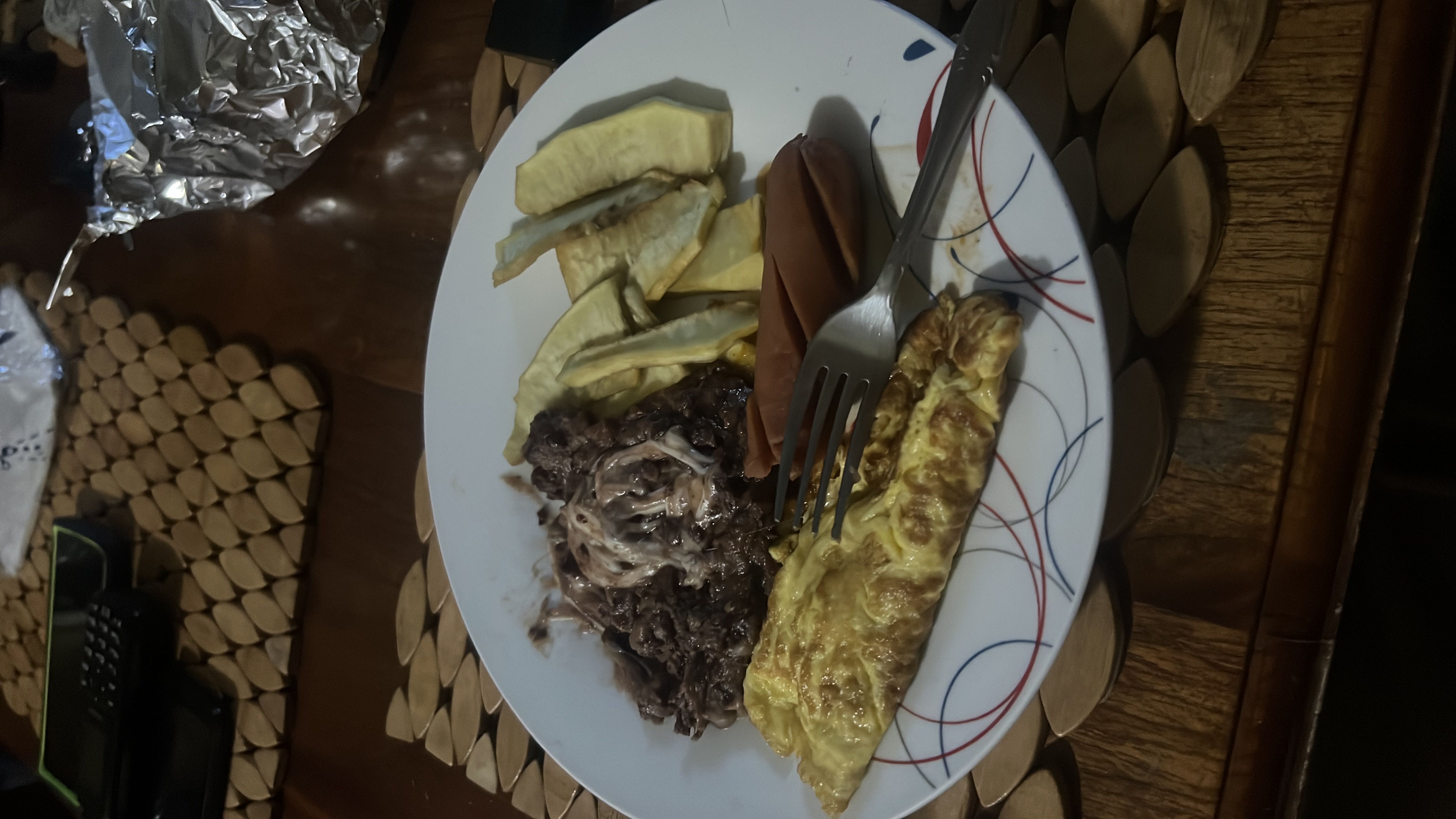 A protein-rich meal consisting of scrambled eggs, sausage, marzipan, and beef with sauce, providing a balanced mix of macronutrients.