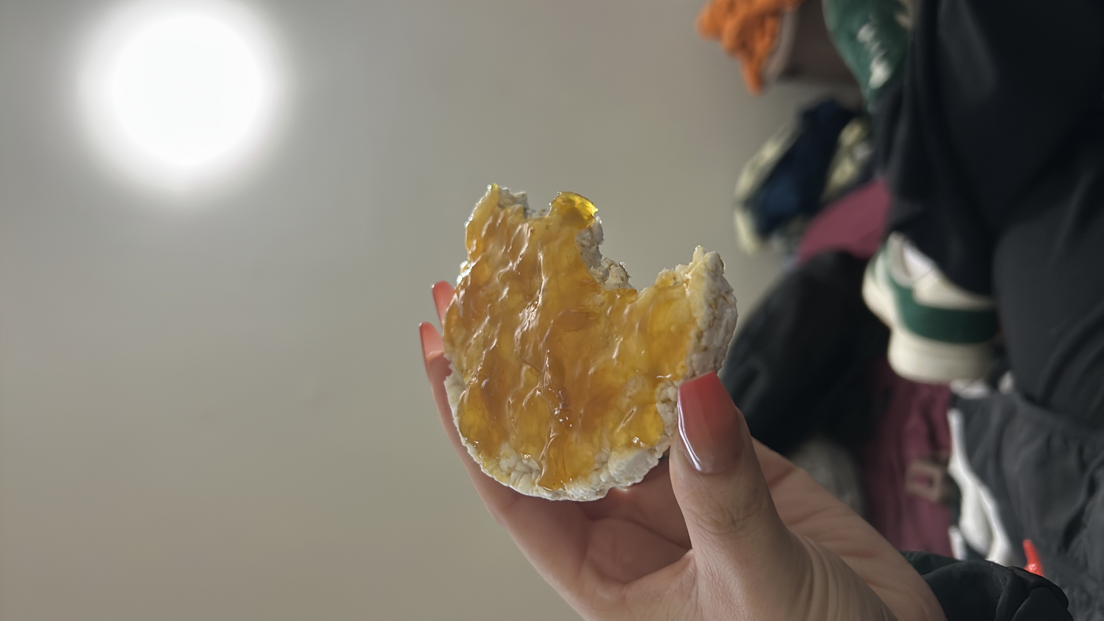 A rice cake topped with honey, providing a light and sweet snack with moderate carbohydrates and minimal fats.