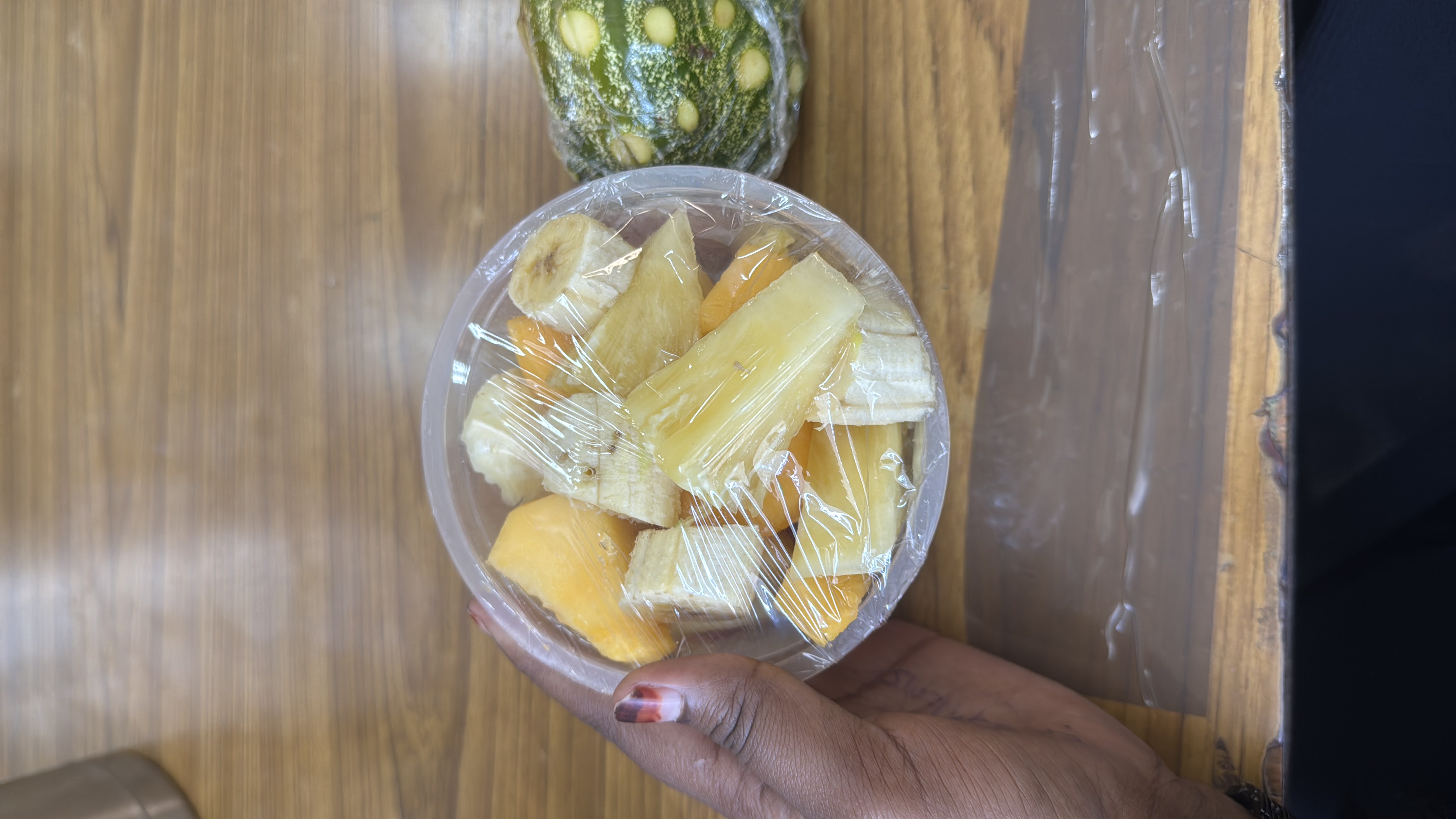A fresh fruit bowl containing banana, pineapple, and papaya, providing a healthy and nutritious snack with natural sugars and fiber.