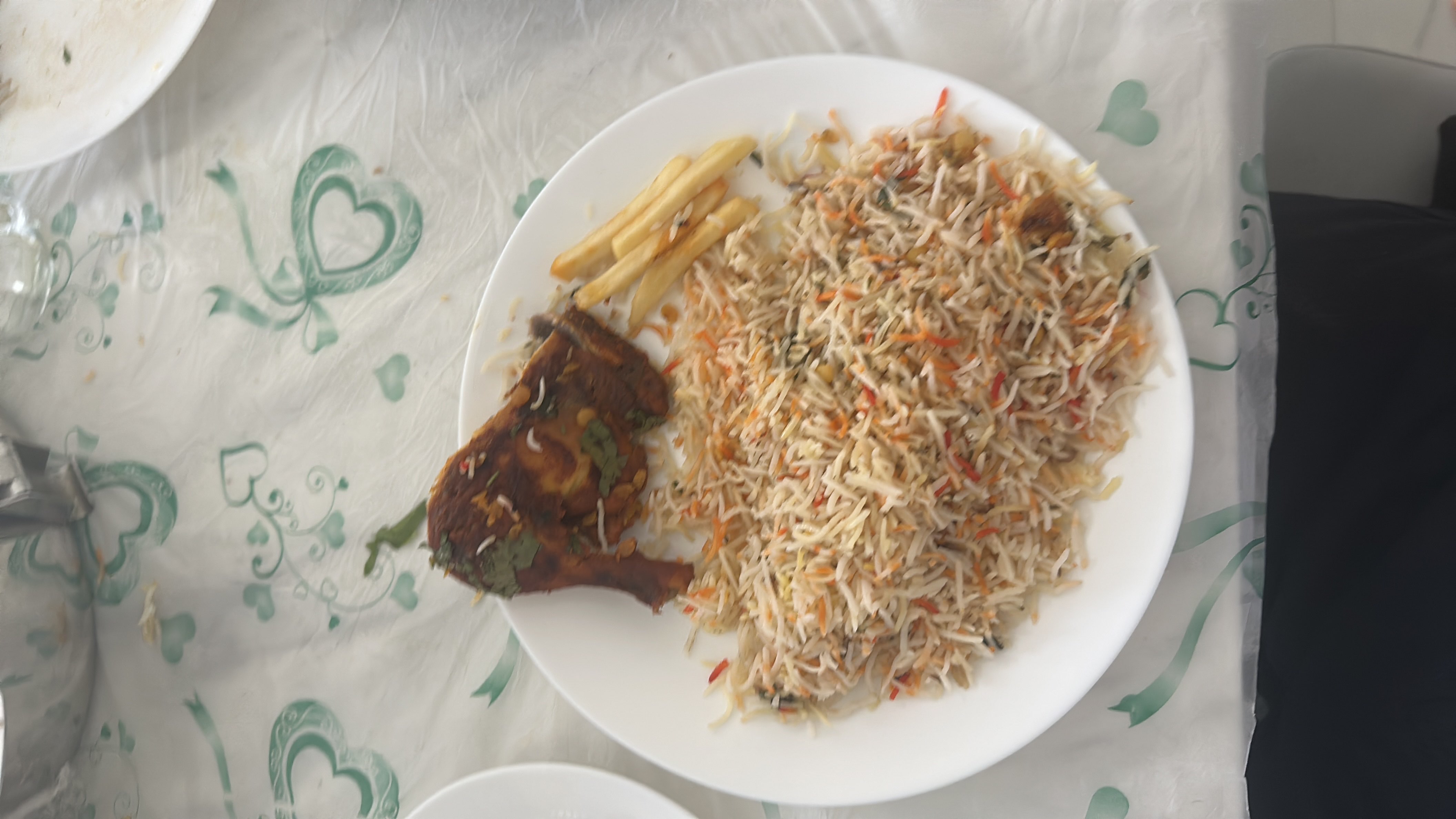A plate of biryani rice with grilled chicken and a side of French fries, providing a balanced mix of protein, carbohydrates, and fats.