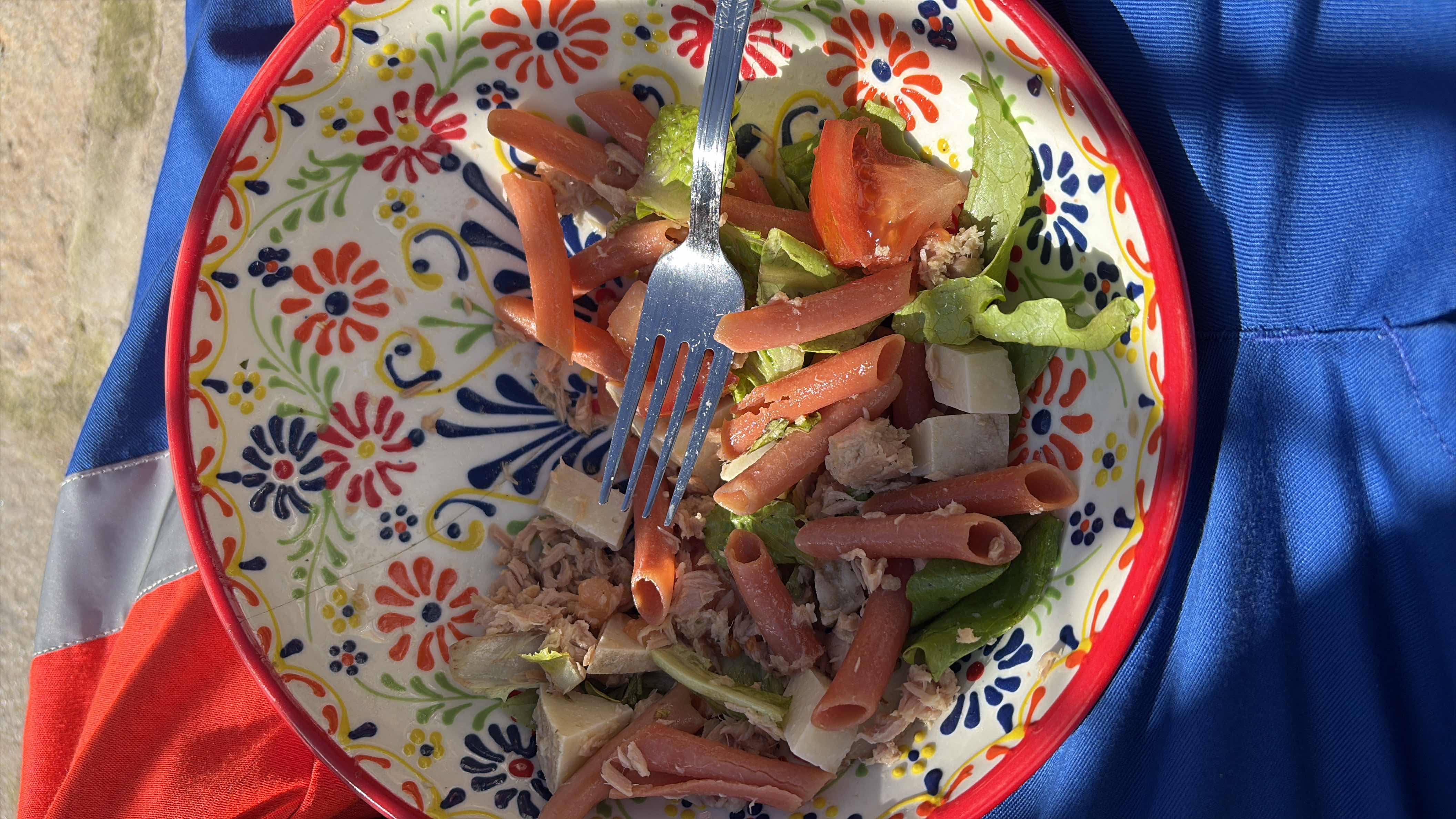 A nutritious pasta salad with red lentil pasta, tuna, lettuce, tomato, and cheese, providing a balanced mix of protein, carbs, and fats.
