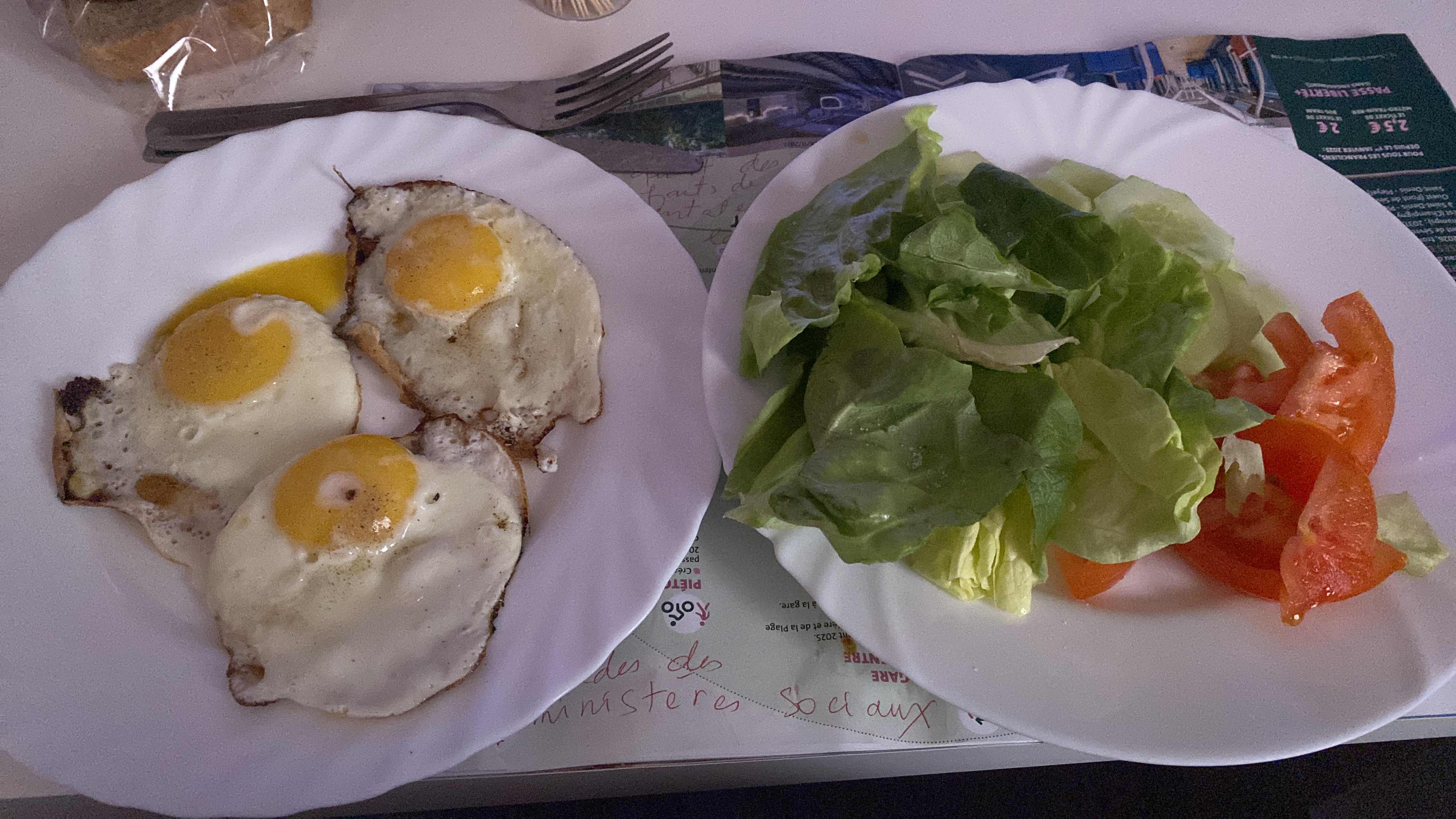 A meal consisting of three fried eggs, fresh lettuce, and sliced tomatoes, providing a balanced mix of protein, fats, and minimal carbs.