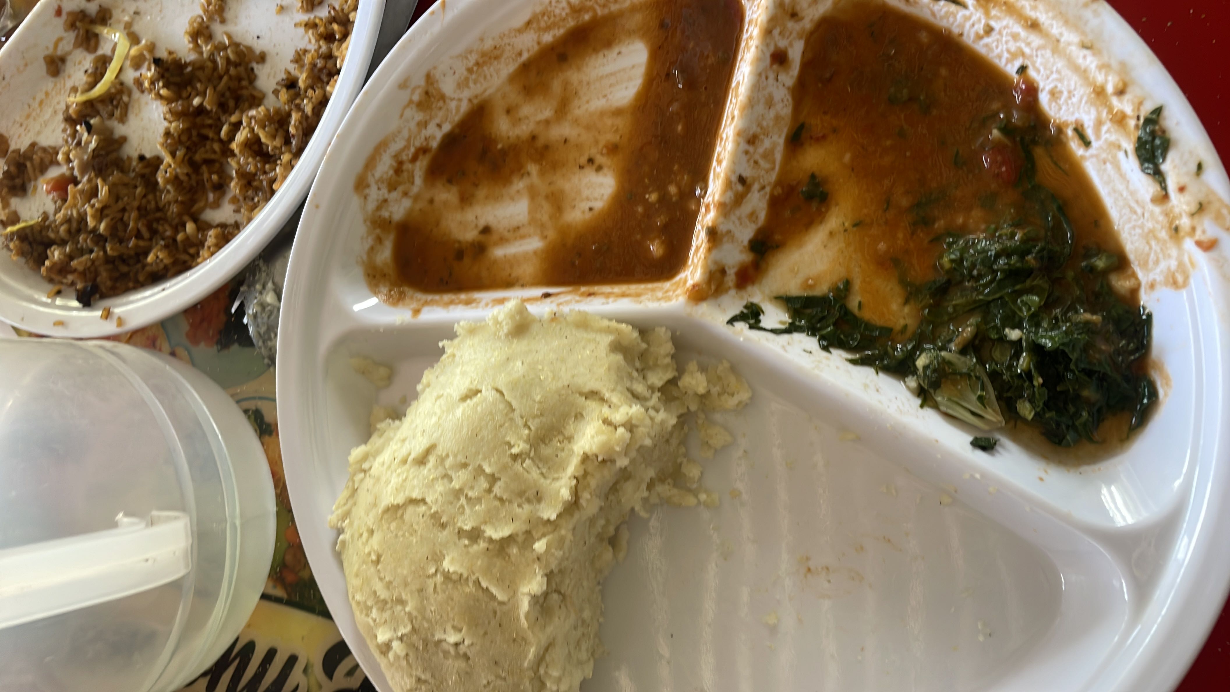 A meal consisting of ugali, greens, sauce, and fried rice, providing a balanced mix of carbohydrates, proteins, and fats.