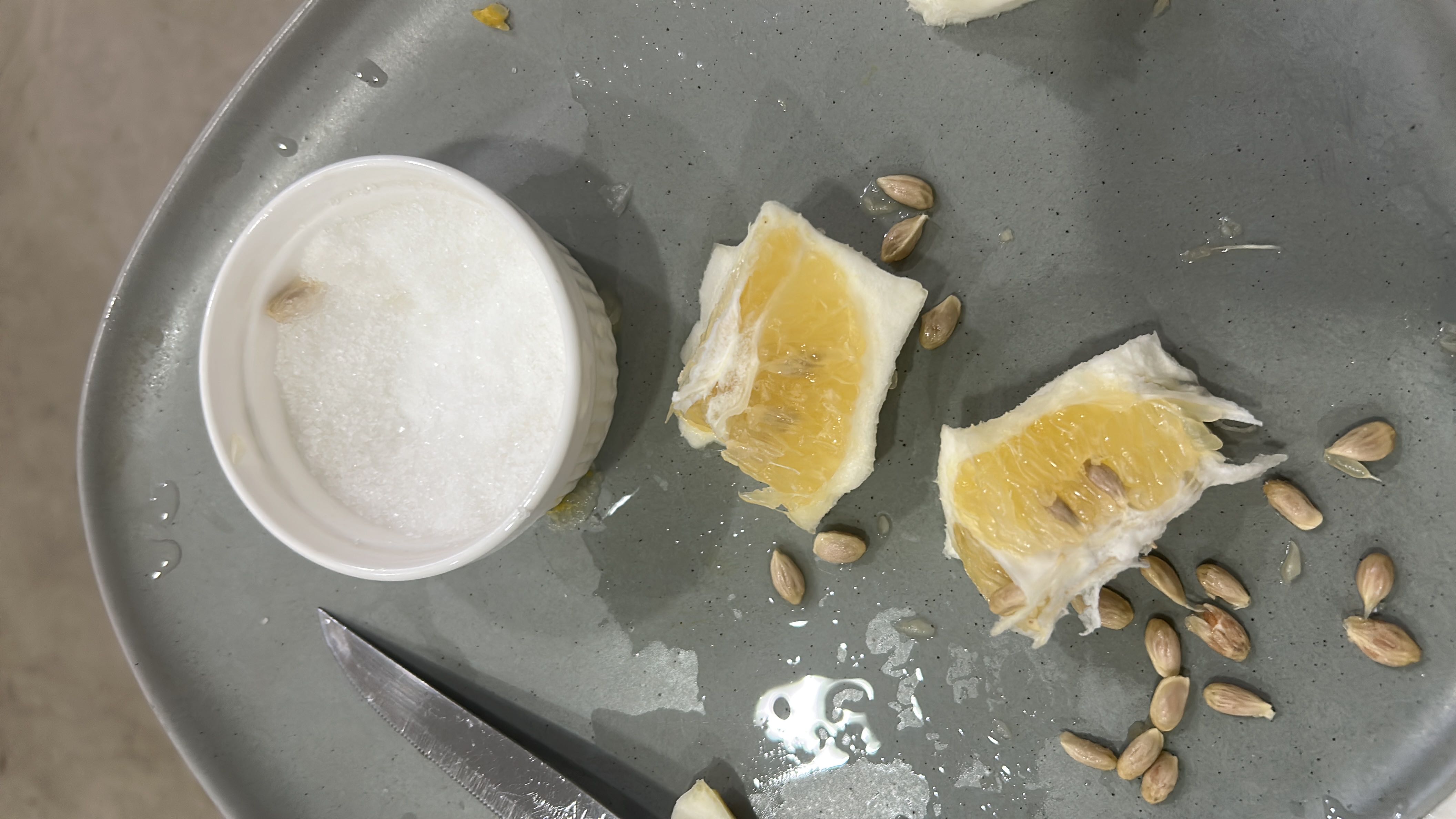 The image shows orange slices, seeds, and a small container of sugar, providing a light and healthy snack option with minimal calories.