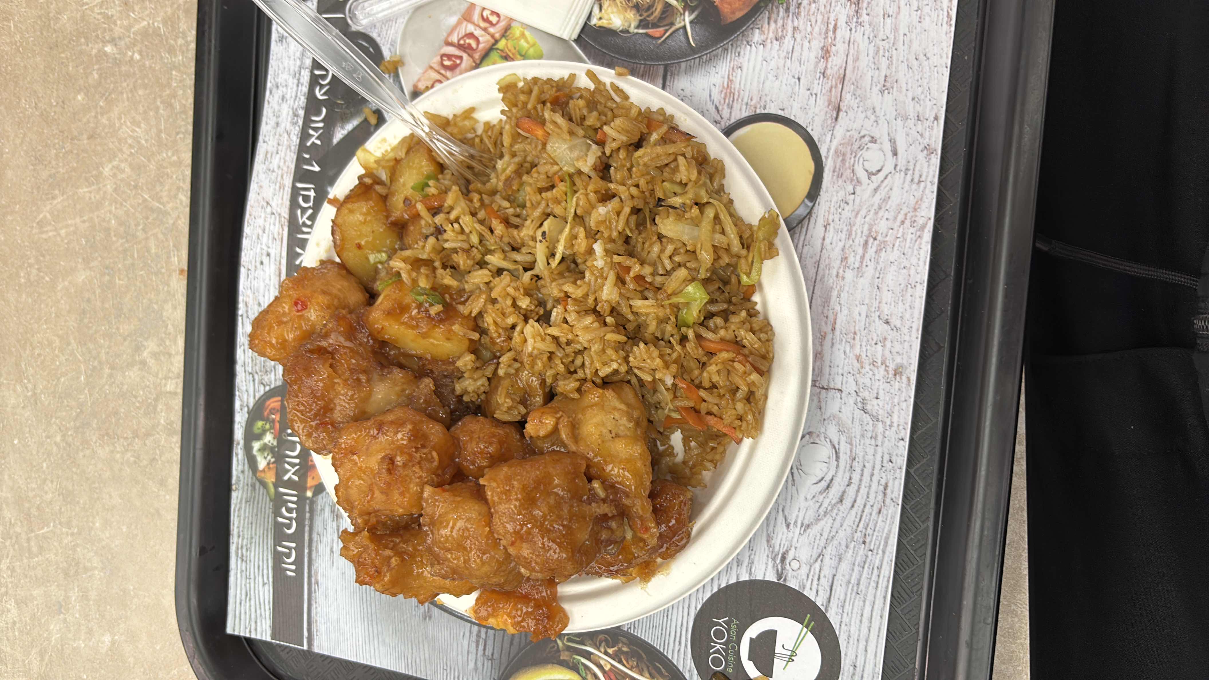 A plate of fried rice with vegetables and sweet and sour chicken, providing a balanced mix of carbs, protein, and fats.