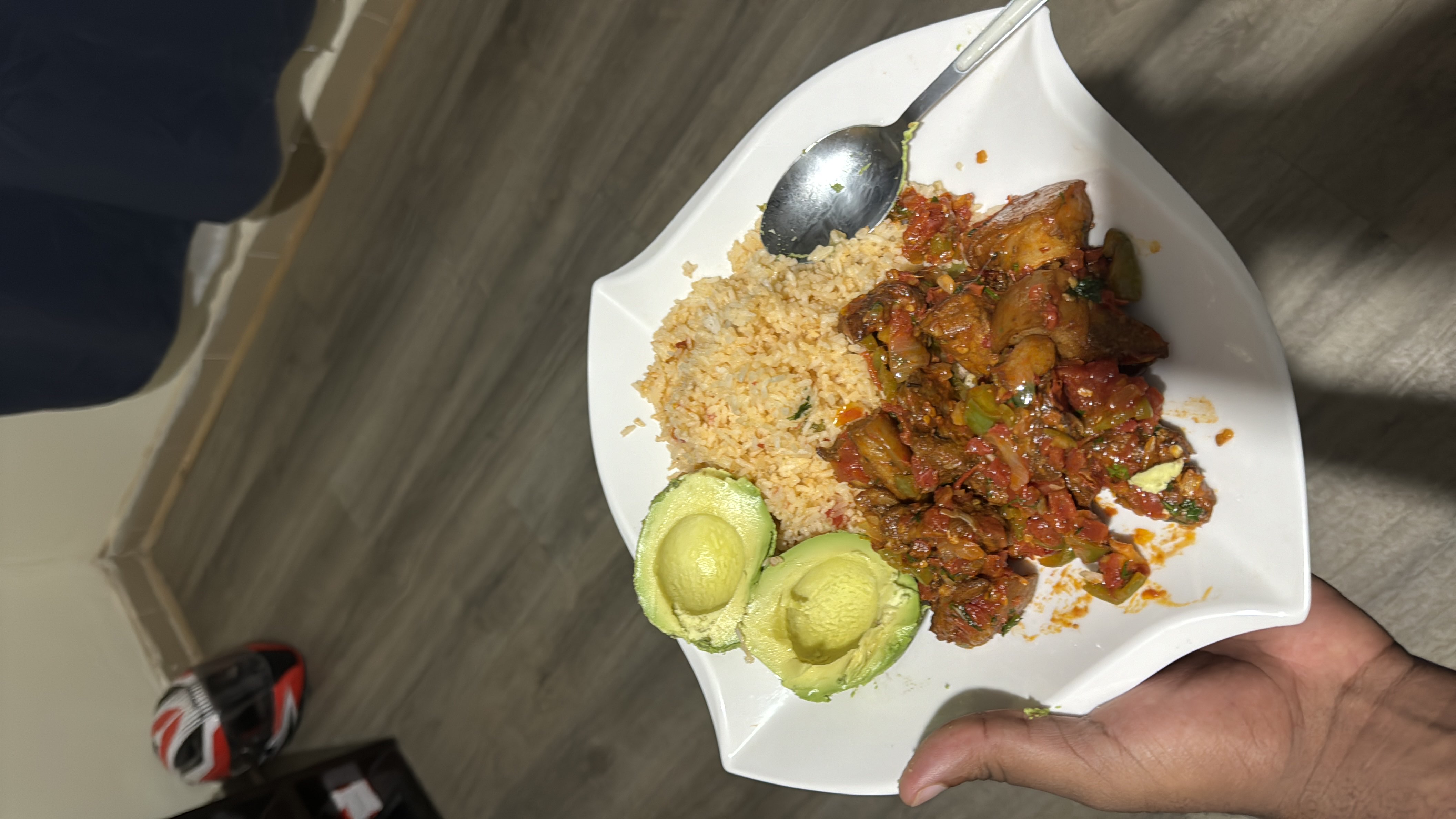 A balanced meal consisting of rice, stewed meat with vegetables, and avocado, providing a good mix of protein, carbohydrates, and healthy fats.