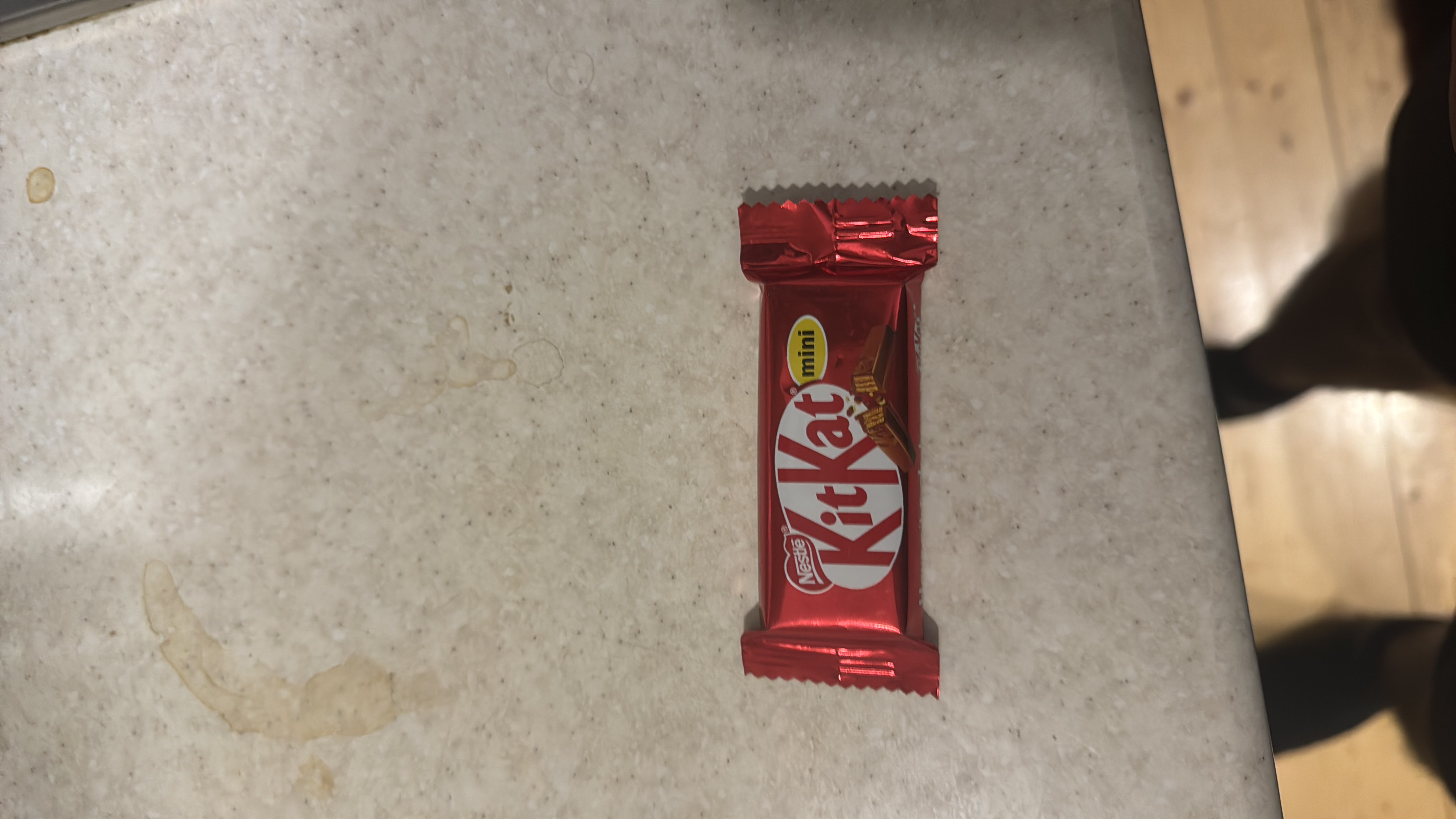 A small Kit Kat Mini chocolate bar with a crispy wafer center, coated in milk chocolate.