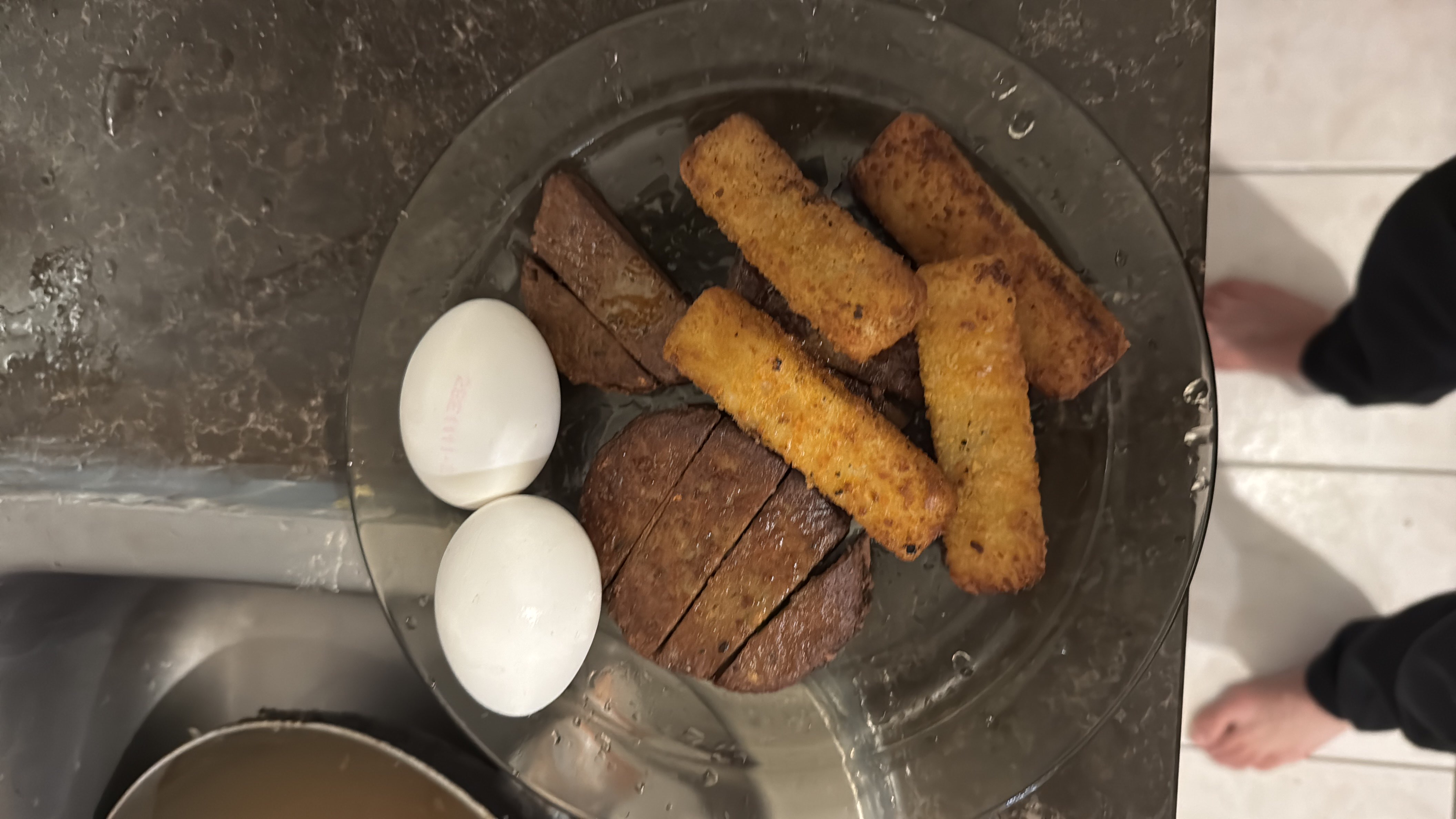 A protein-rich meal consisting of boiled eggs, a beef patty, and fried potato sticks, providing a balanced mix of protein, fats, and carbohydrates.