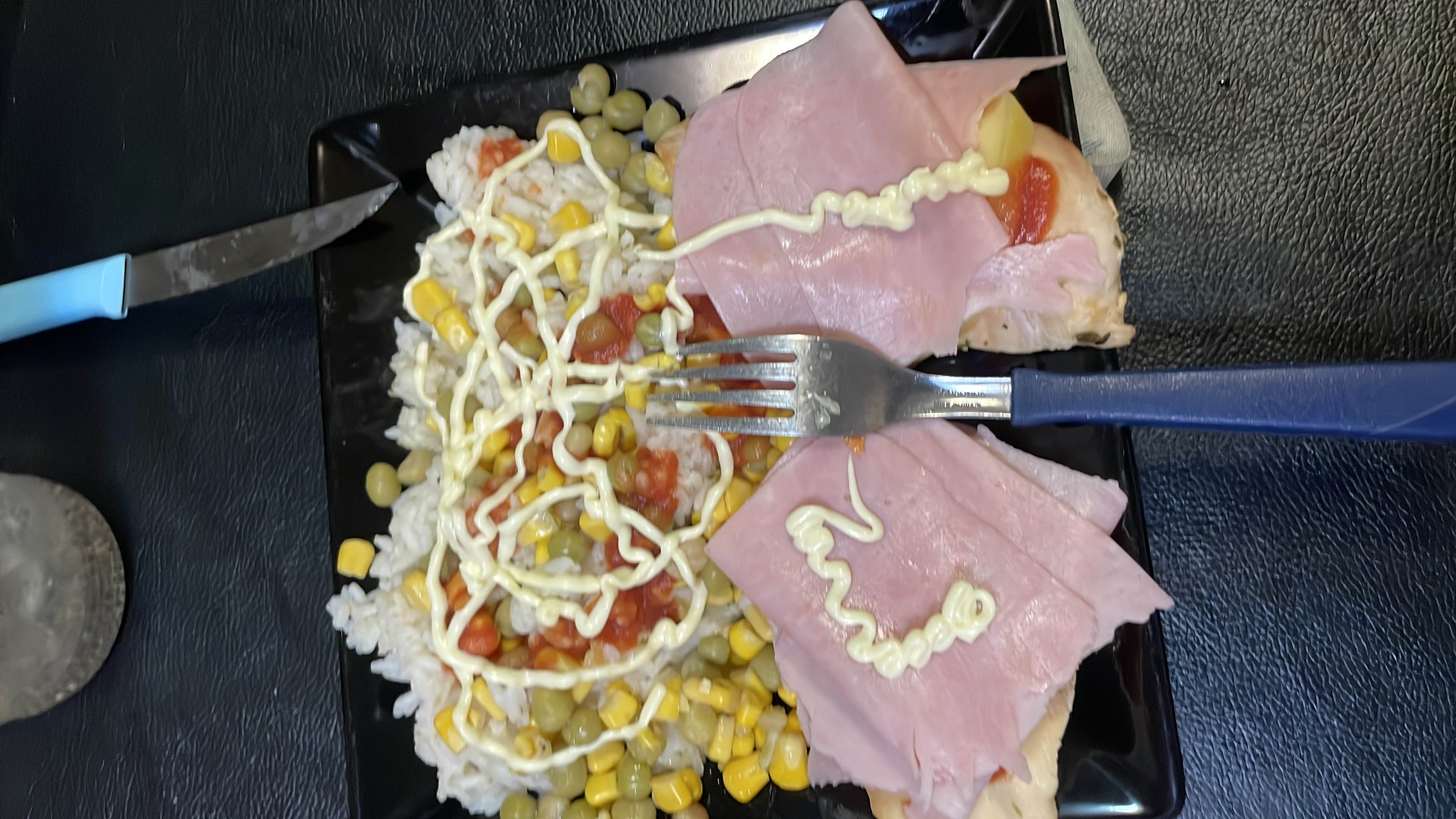 A meal consisting of rice, ham, chicken, corn, peas, and mayonnaise, providing a balanced mix of protein, carbohydrates, and fats.