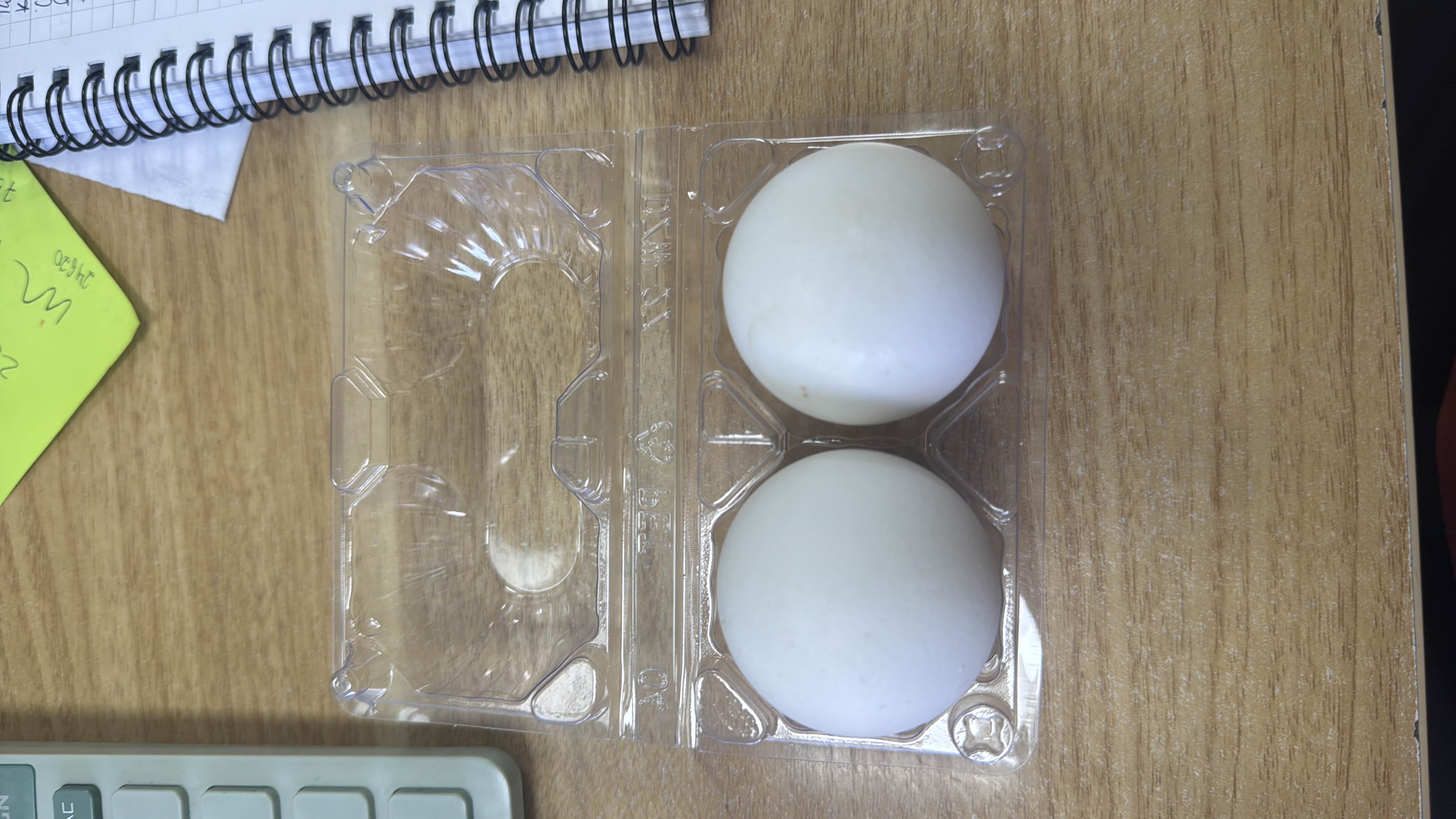 The image shows two eggs in a plastic container. Eggs are a rich source of protein and healthy fats, making them a nutritious food choice.
