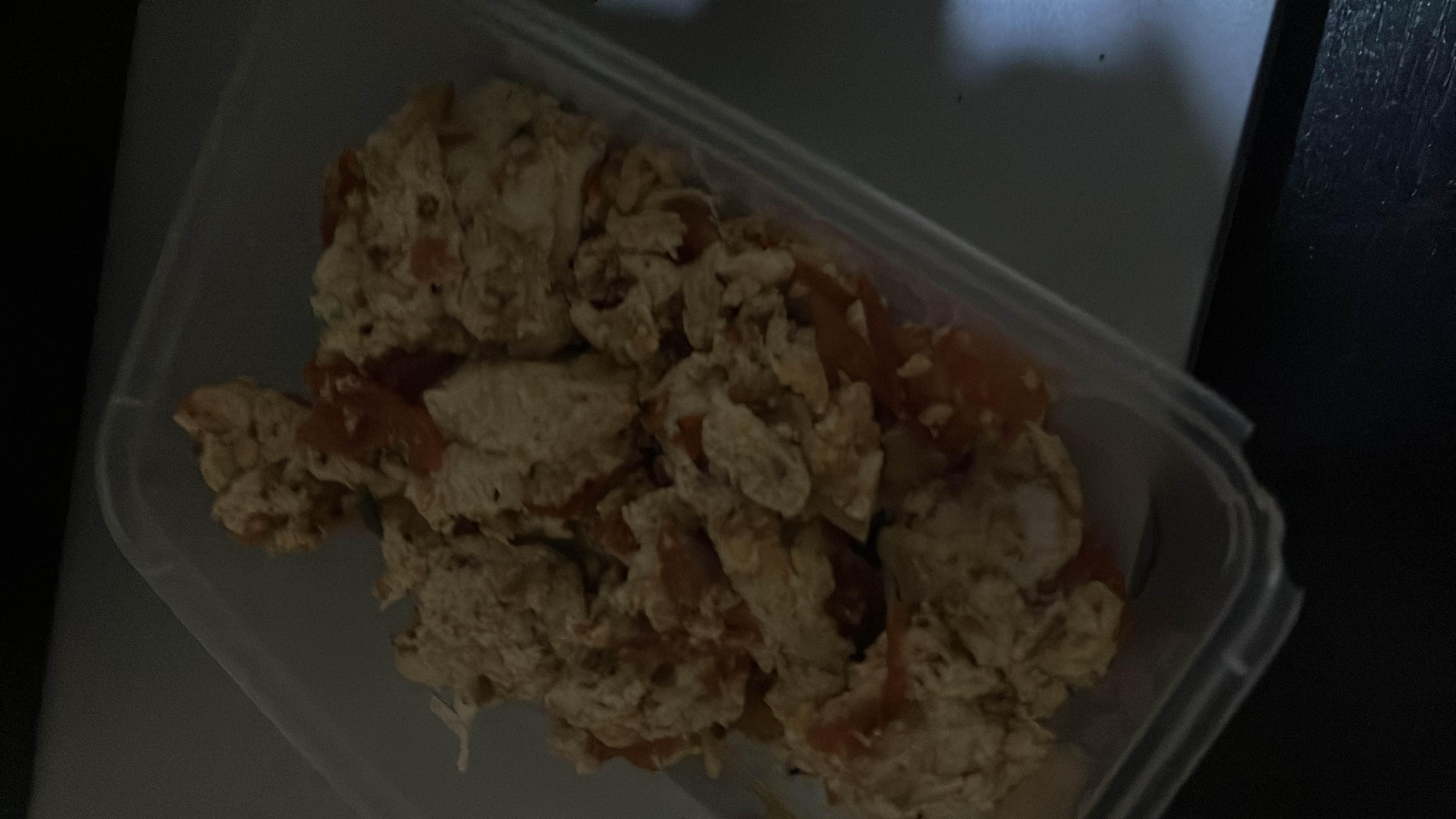 A protein-rich scrambled egg dish with tomatoes and onions, cooked with a small amount of oil.