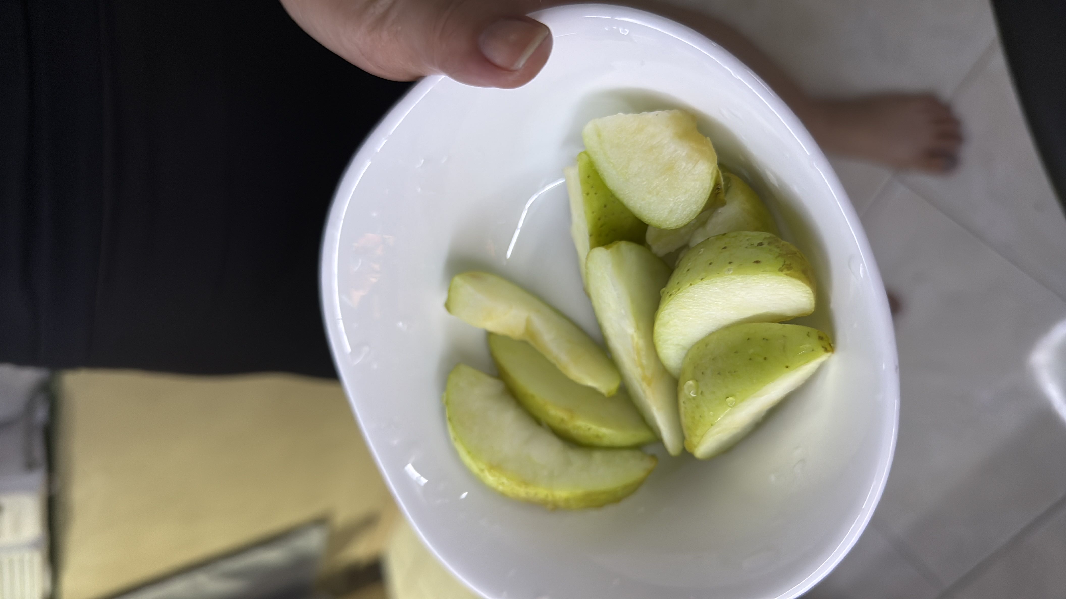 A bowl of freshly sliced green apple, a low-calorie fruit rich in fiber and vitamin C.