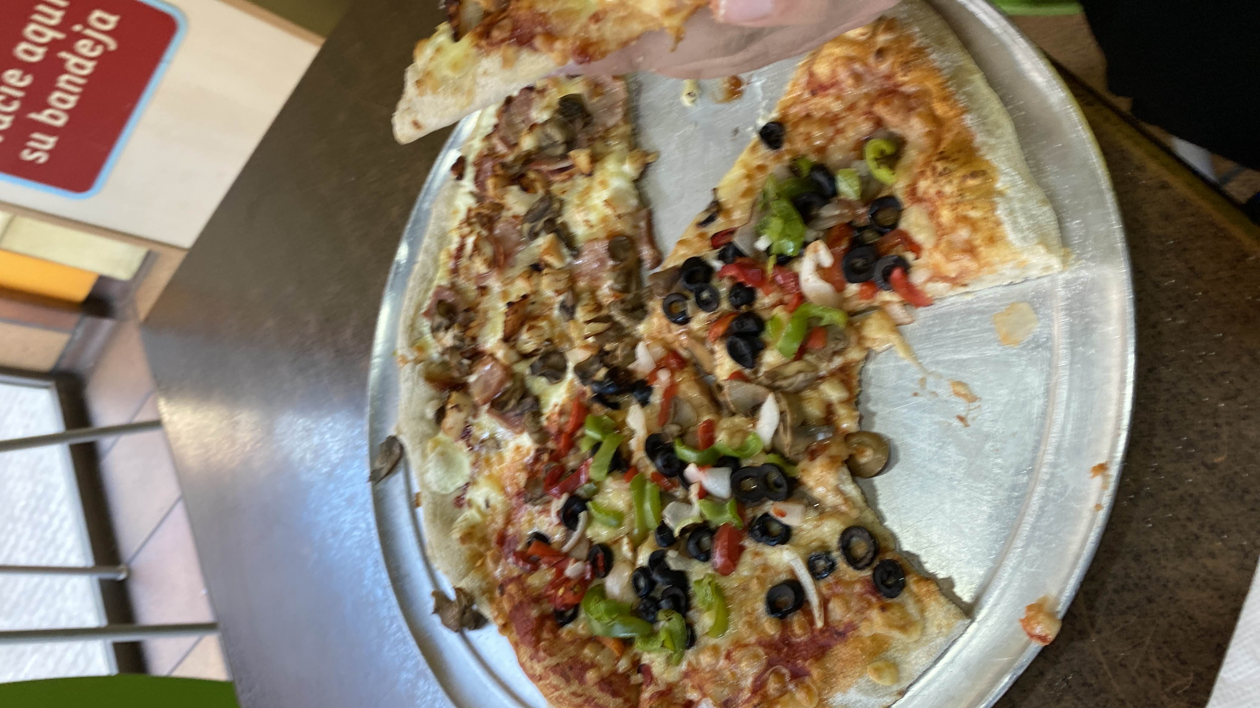 A vegetable and cheese pizza with toppings including olives, bell peppers, and mushrooms, served on a thin crust.