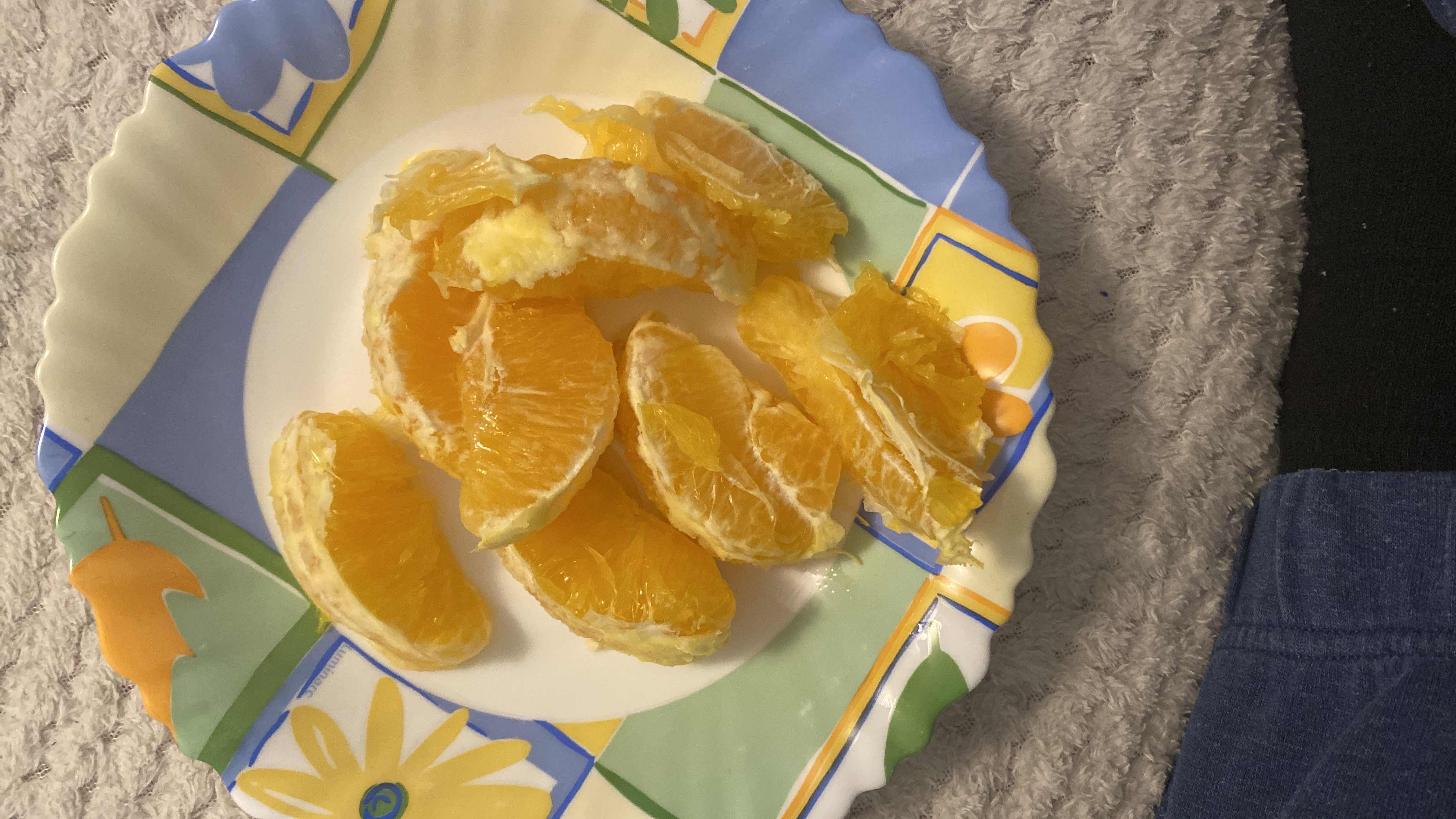 A plate with freshly peeled orange slices, providing a healthy and vitamin-rich snack.