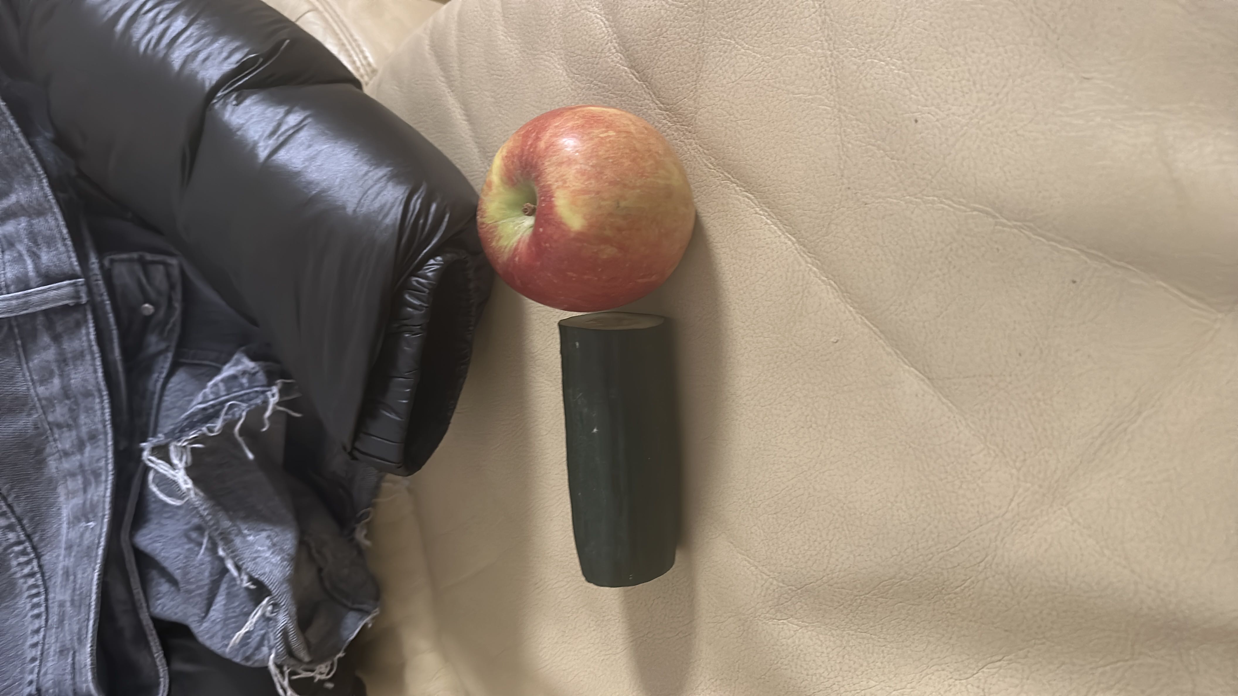 The image shows an apple and a piece of cucumber, which are low-calorie, nutrient-rich foods.