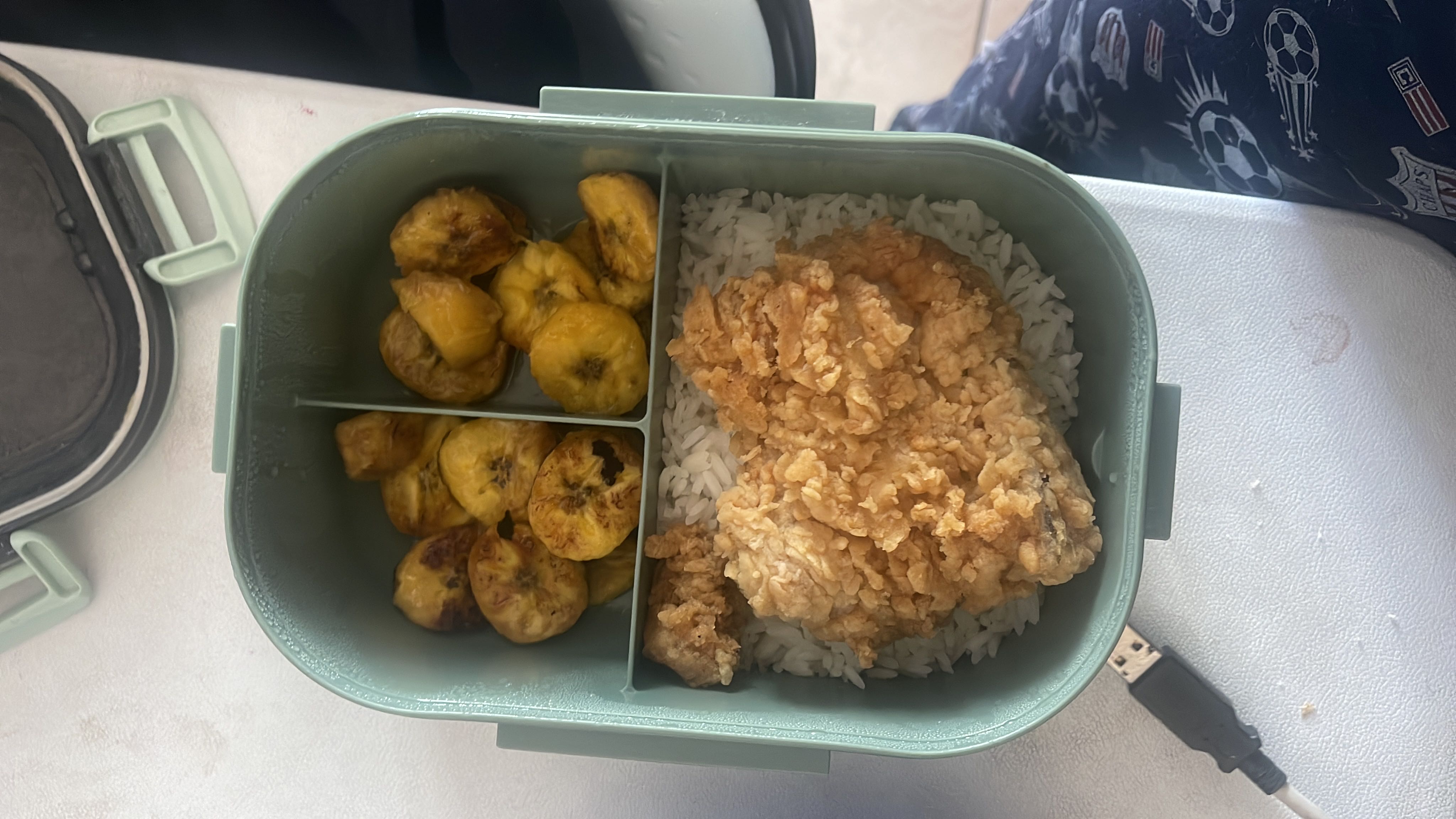A meal consisting of white rice, crispy fried chicken, and fried plantains, providing a balanced mix of carbohydrates, protein, and fats.
