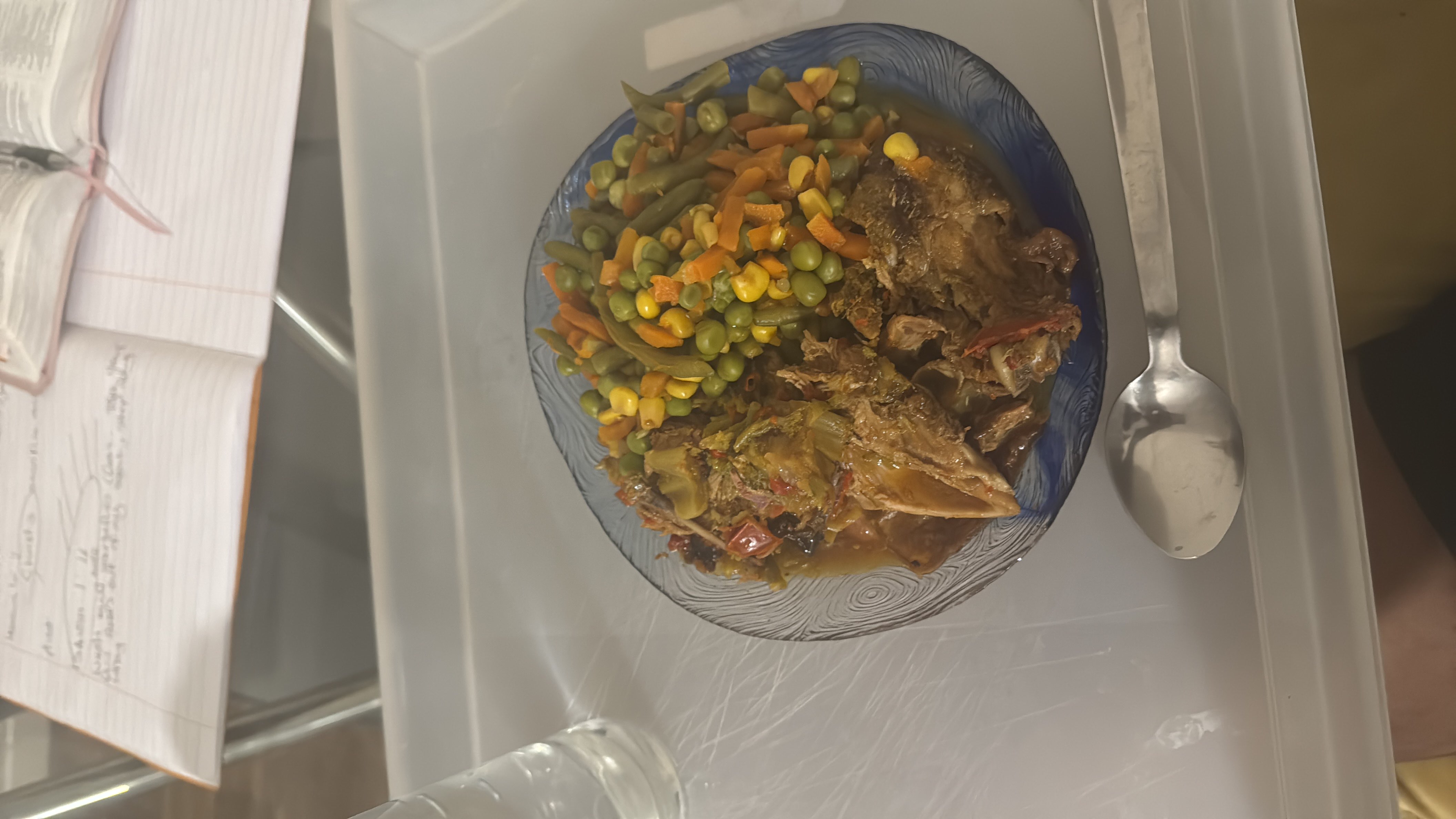 A nutritious meal consisting of braised meat and a mix of vegetables including peas, carrots, corn, and green beans.
