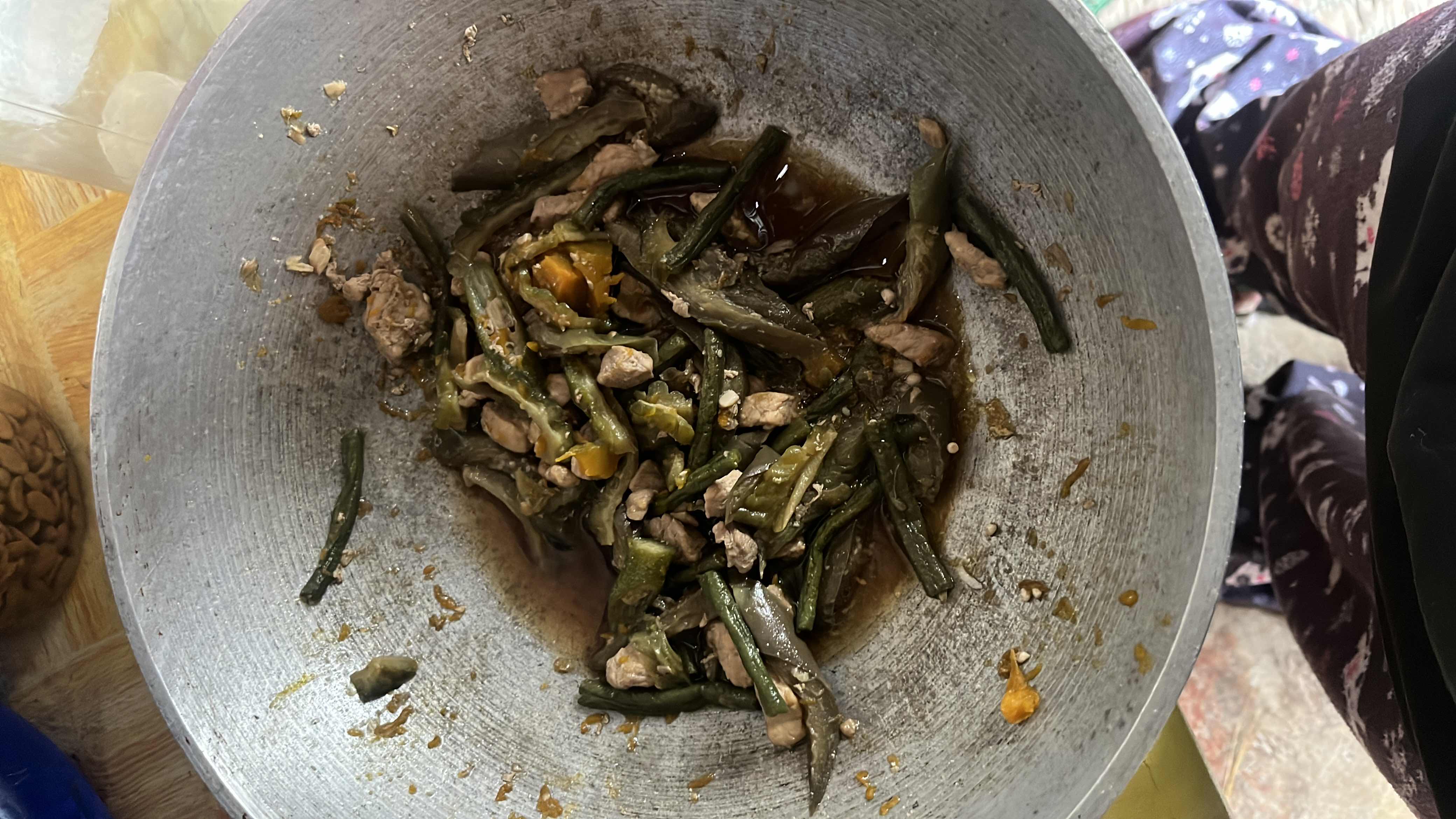 A stir-fried dish with bitter melon, green beans, and pork cooked in soy sauce with garlic and onions, offering a balanced mix of protein, fiber, and essential nutrients.