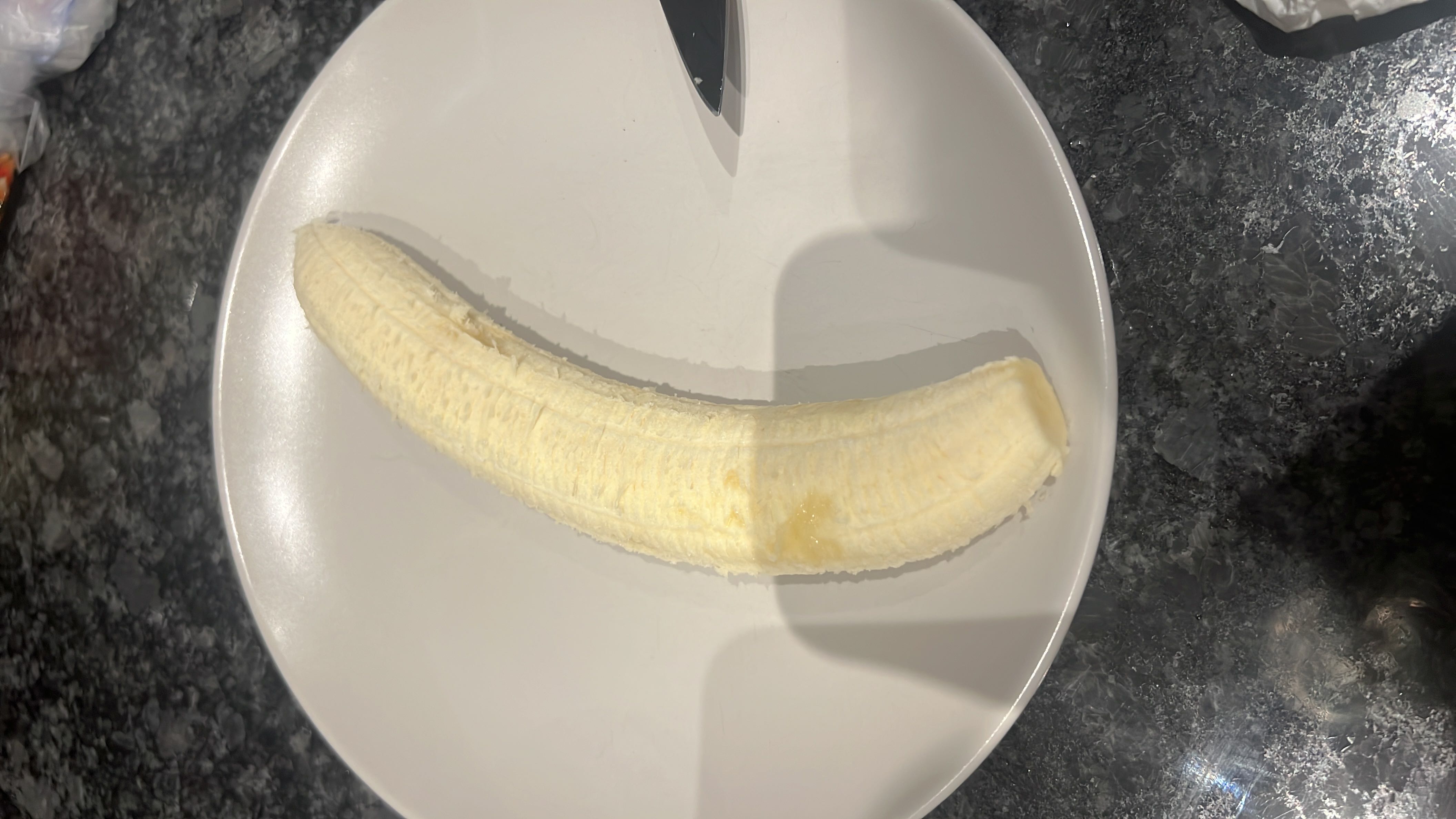 A peeled banana on a plate, providing a good source of carbohydrates and essential nutrients.