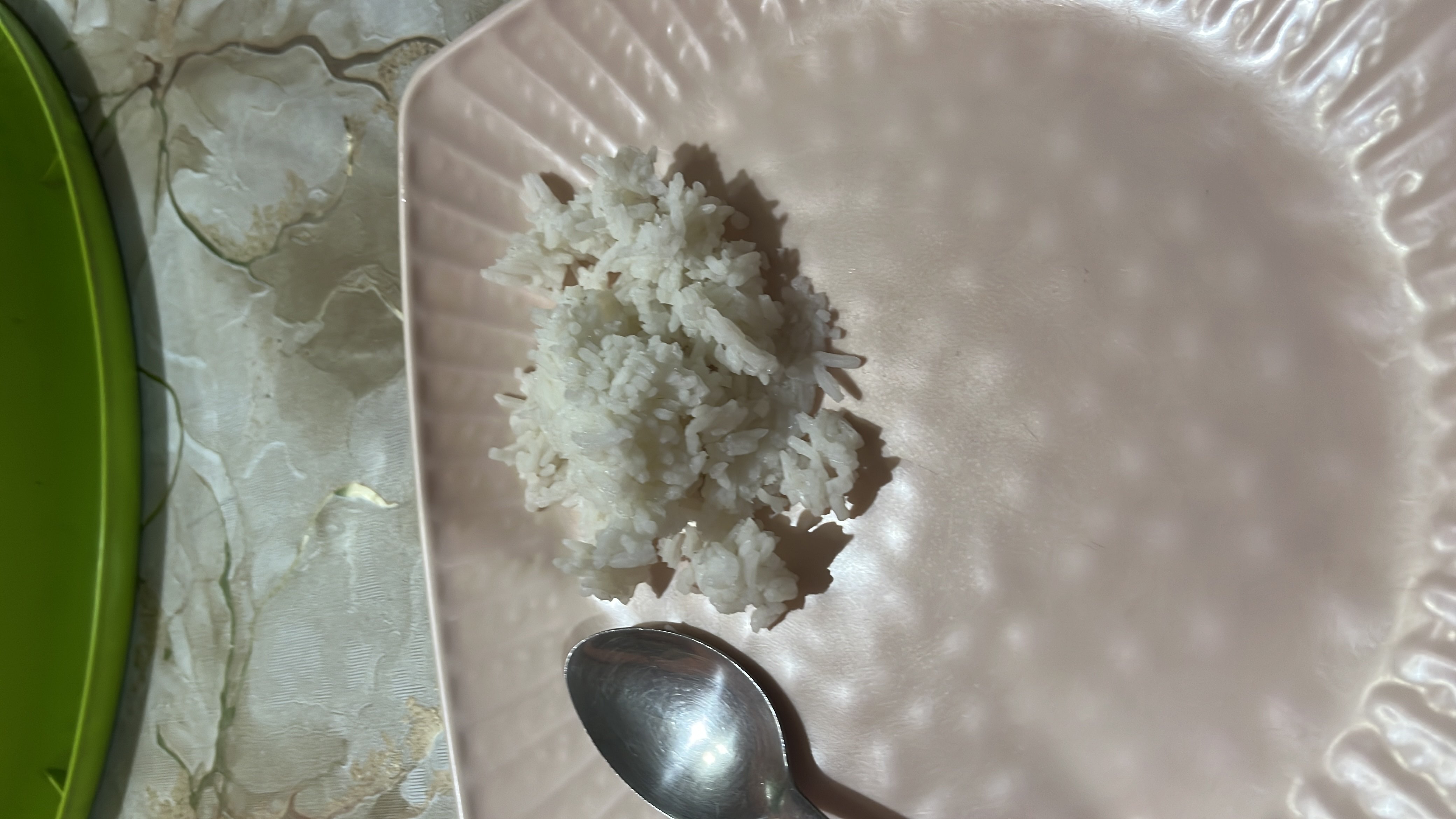 A small portion of cooked white rice served on a plate, providing a moderate amount of carbohydrates with minimal protein and fats.