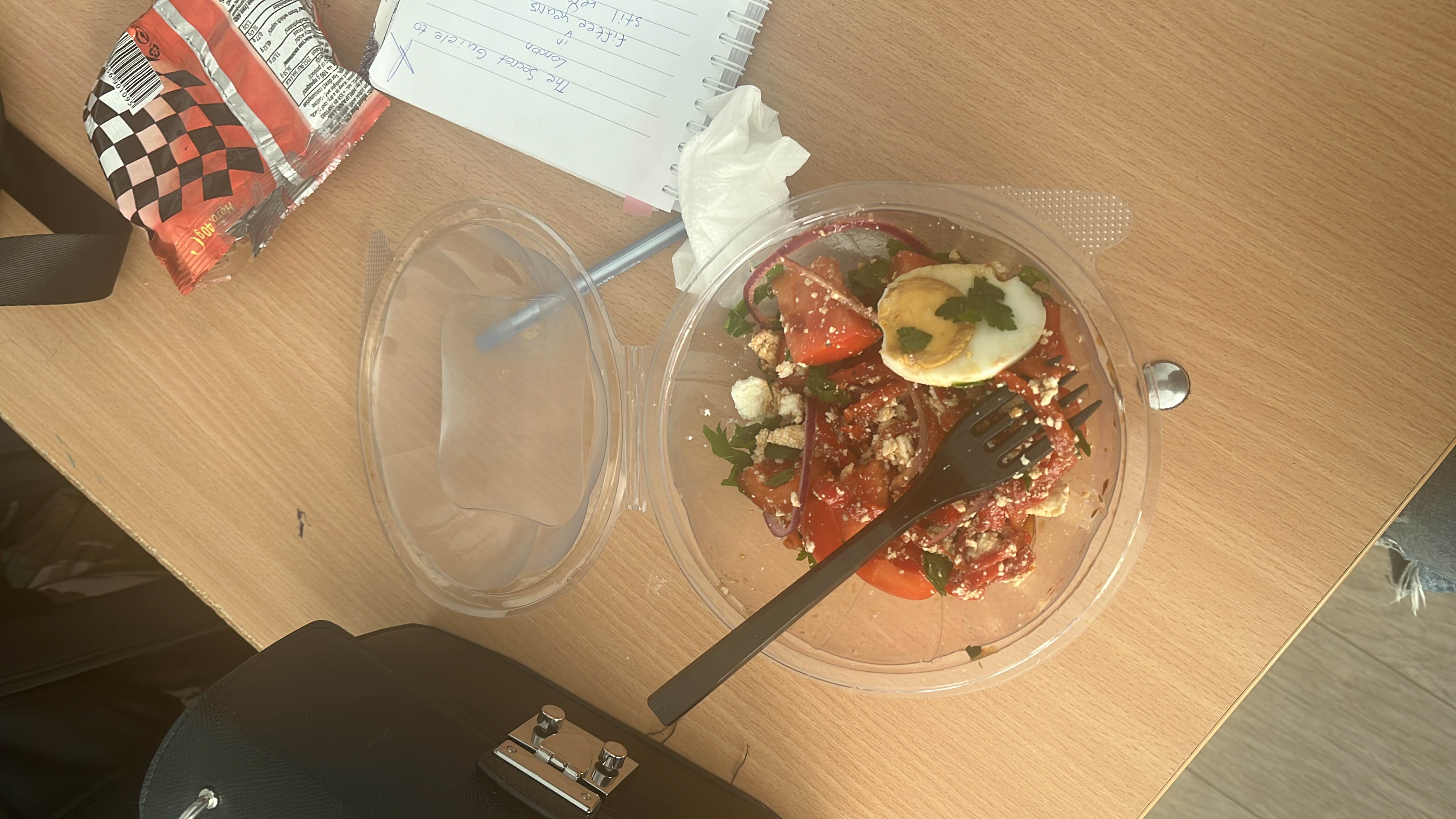 A fresh and healthy salad containing tomatoes, feta cheese, boiled egg, red onion, and parsley, providing a balanced mix of protein, fats, and carbohydrates.