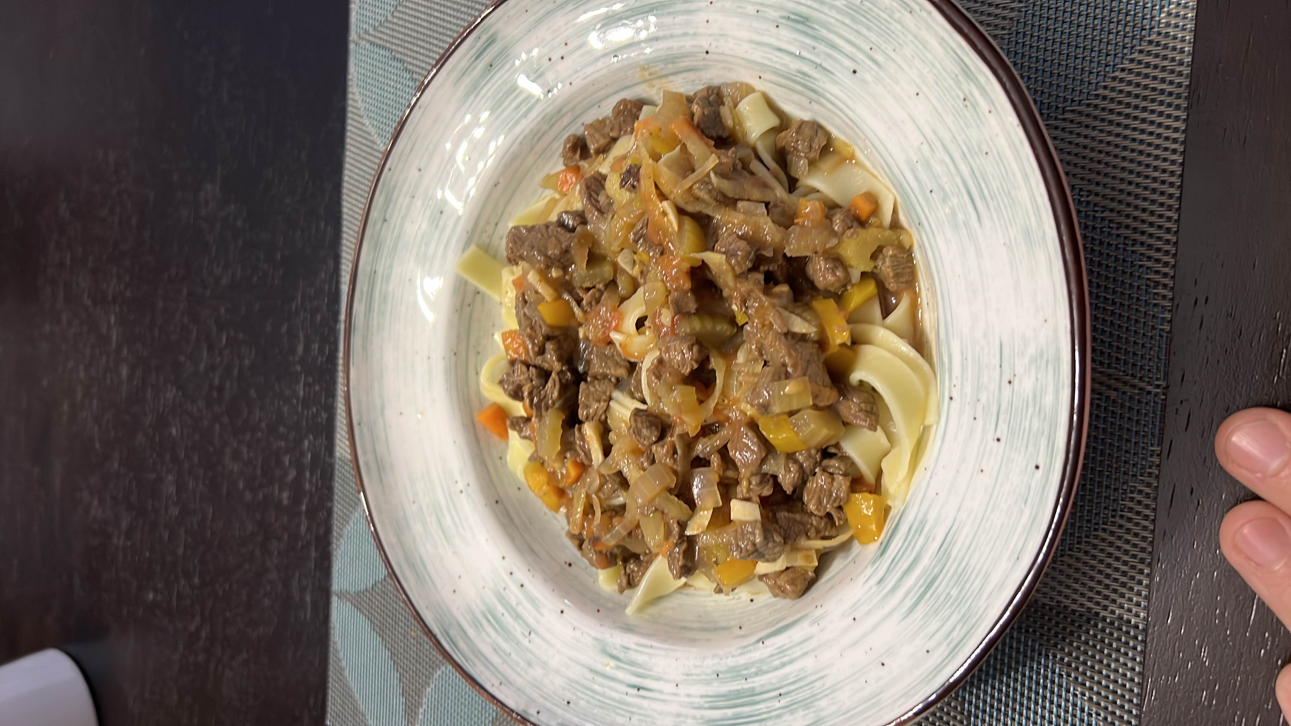 A hearty dish of beef and vegetables served over egg noodles, providing a balanced mix of protein, carbs, and fats.