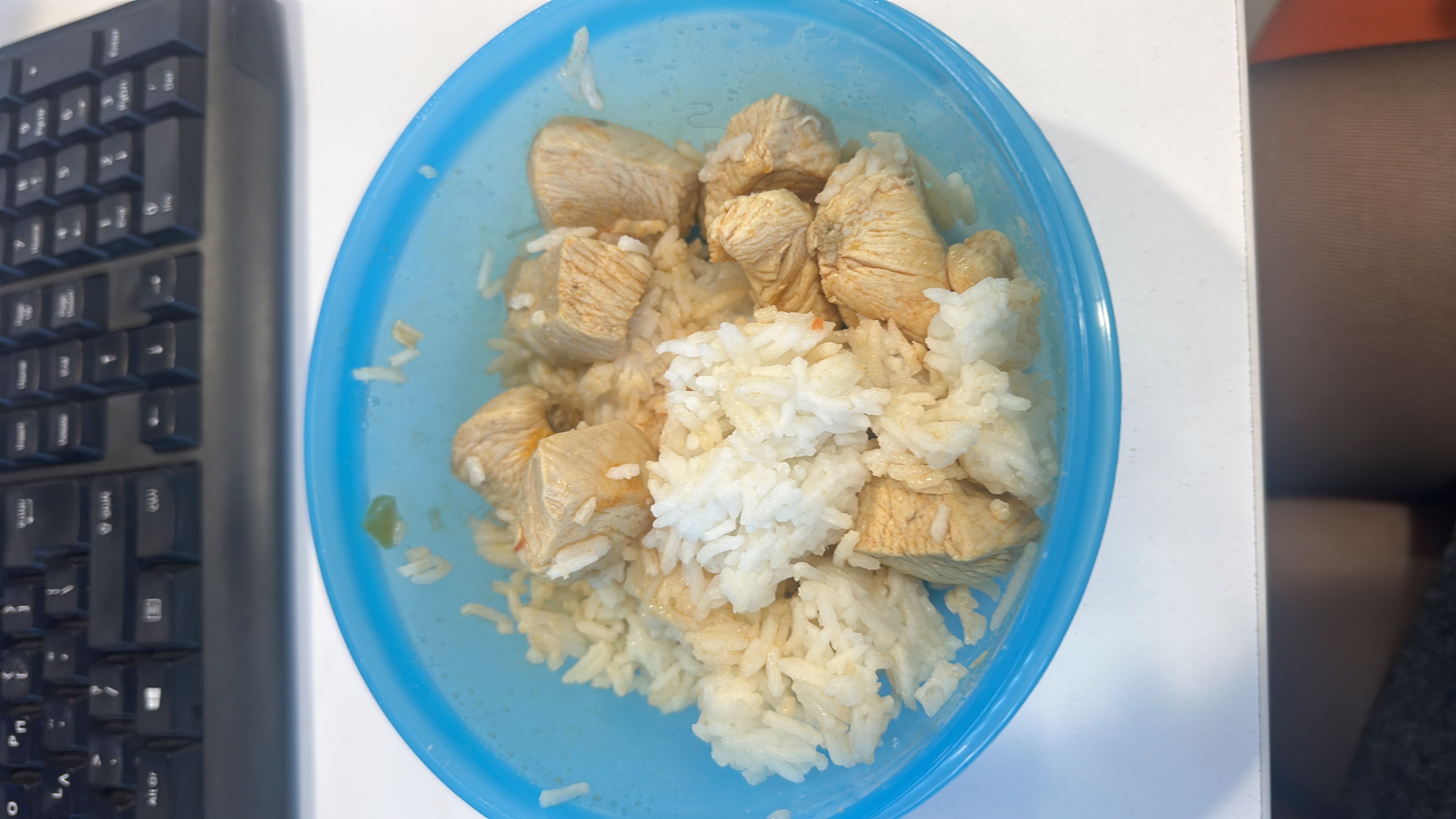 A simple meal consisting of cooked white rice and grilled chicken breast, providing a balanced mix of protein and carbohydrates.