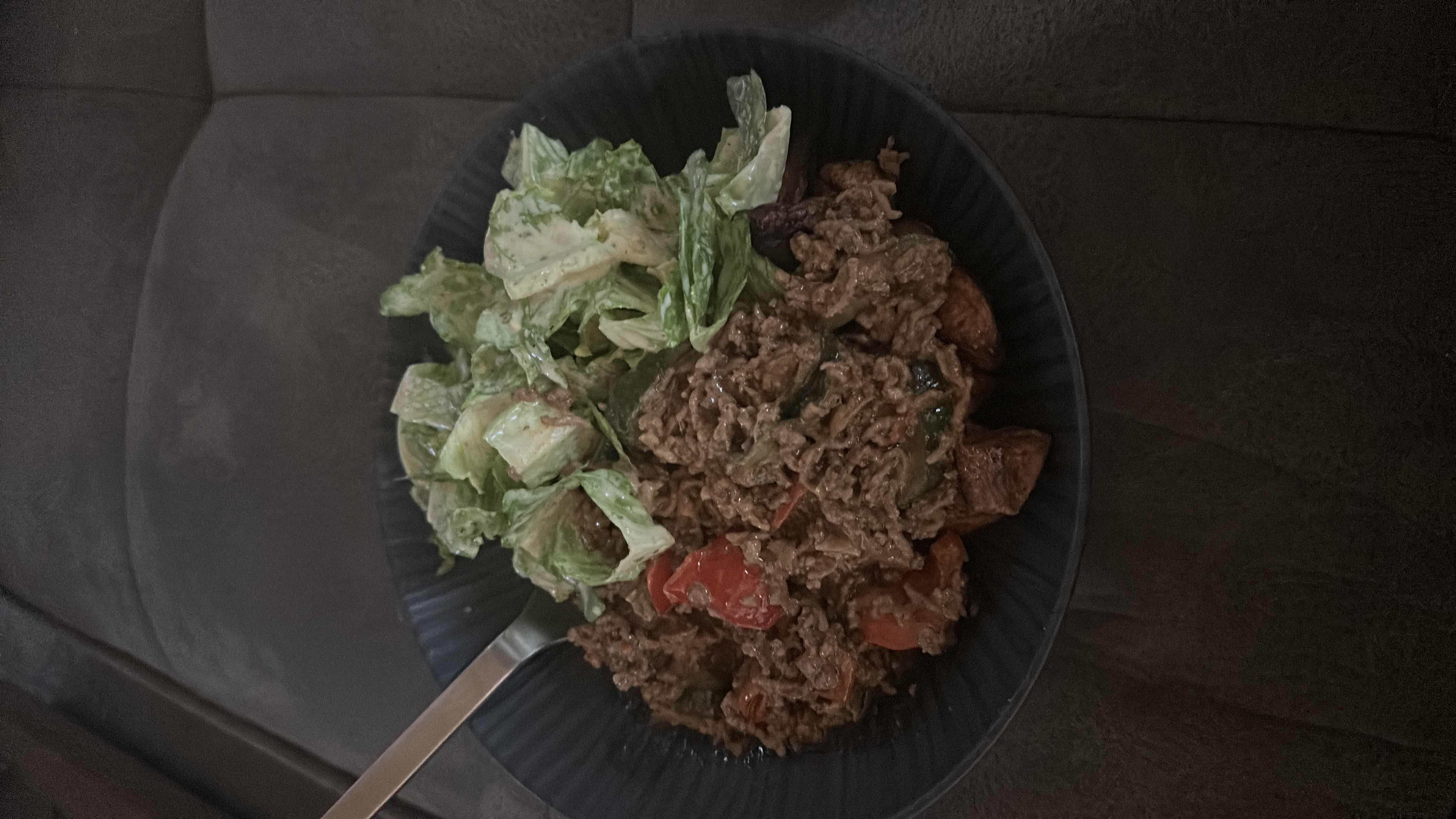 A balanced meal consisting of seasoned ground beef with vegetables, roasted potatoes, and a fresh lettuce salad with dressing.