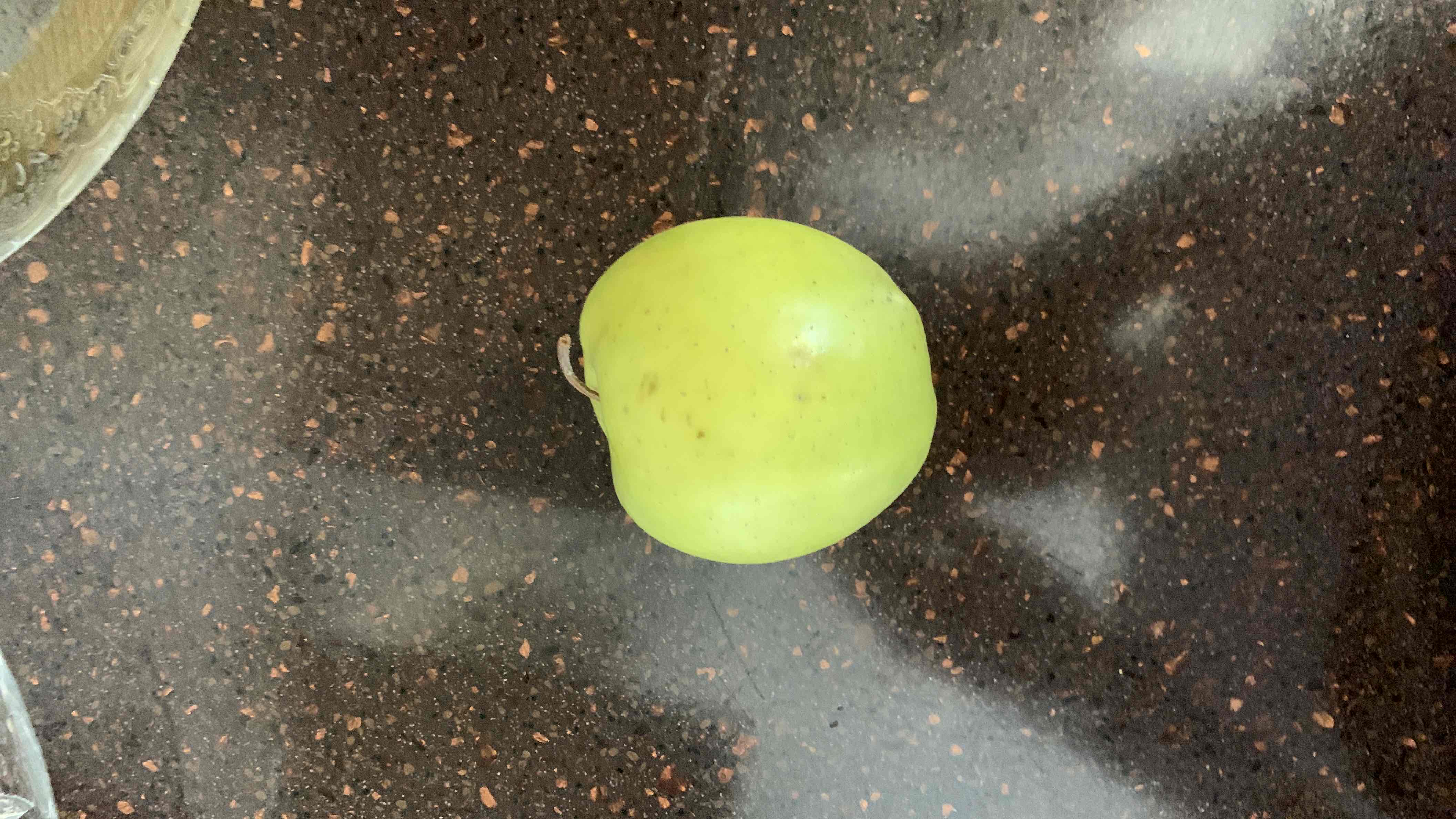 A fresh green apple, rich in fiber and vitamins, providing a healthy and low-calorie snack option.