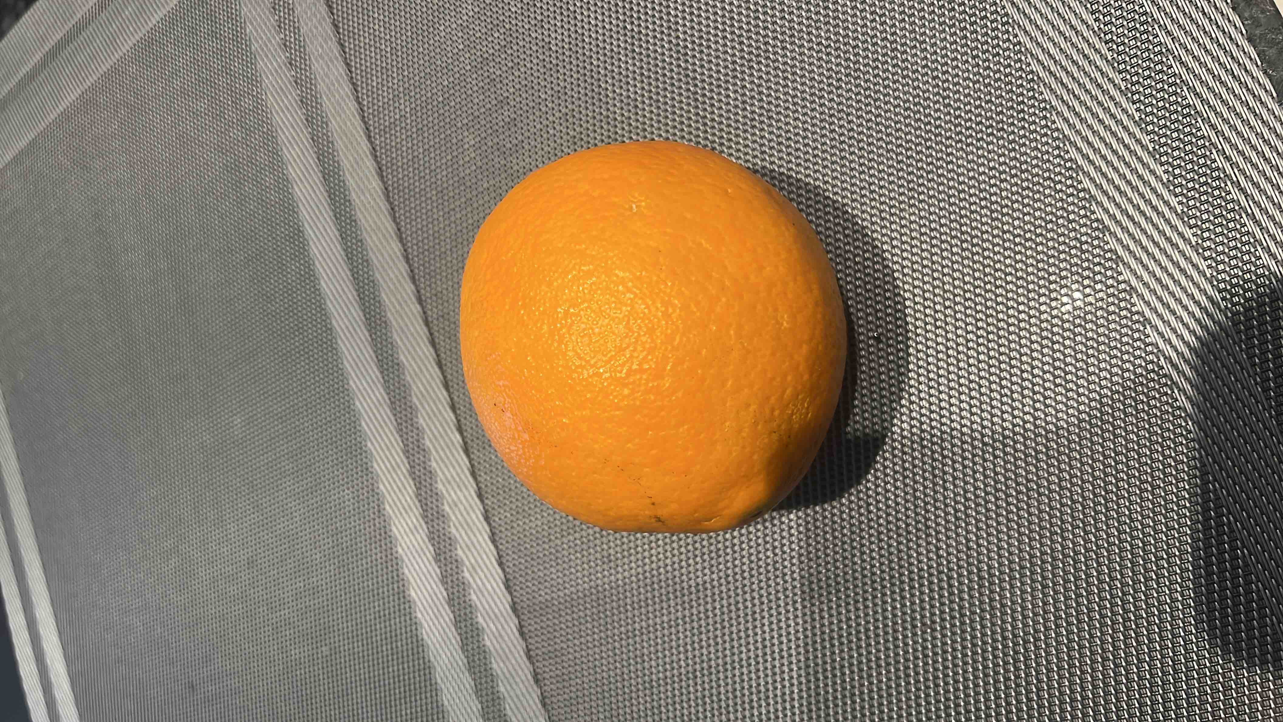 A fresh orange, rich in vitamin C, low in calories, and high in fiber, making it a nutritious and healthy fruit choice.