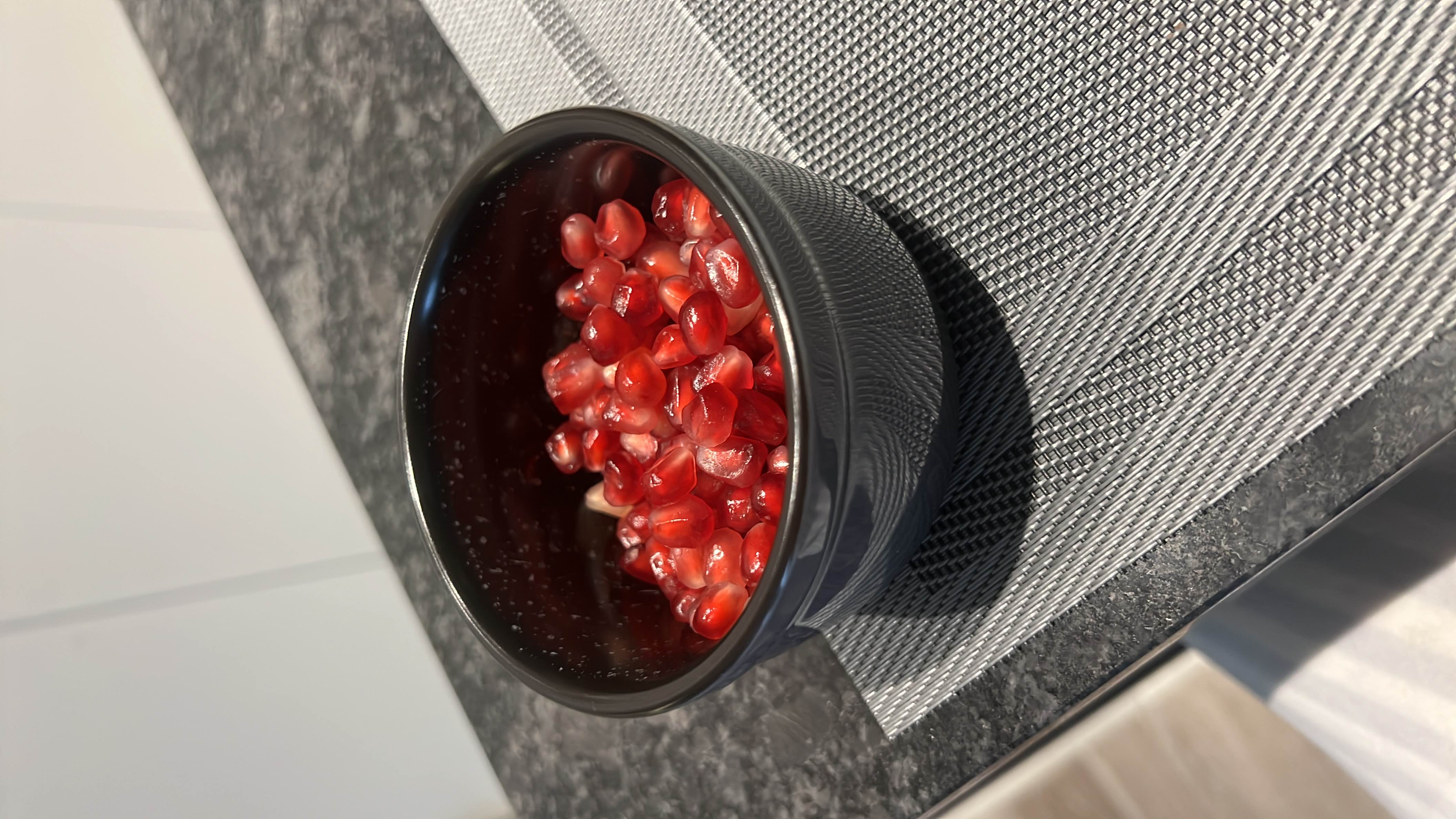 A bowl of fresh pomegranate seeds, rich in antioxidants, vitamins, and fiber, offering a nutritious and refreshing snack.