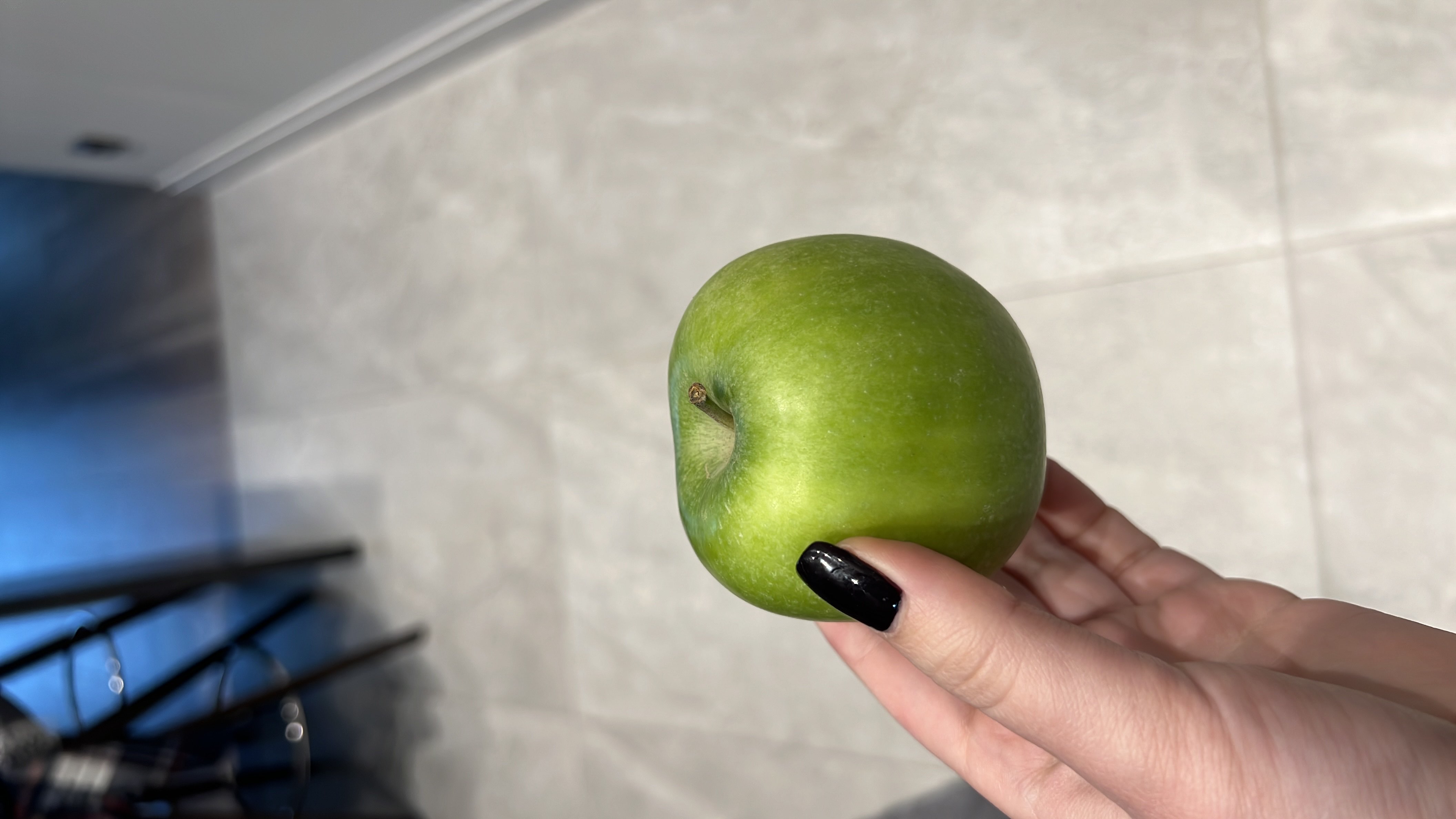 A fresh green apple, rich in fiber and vitamins, providing a healthy and low-calorie snack option.