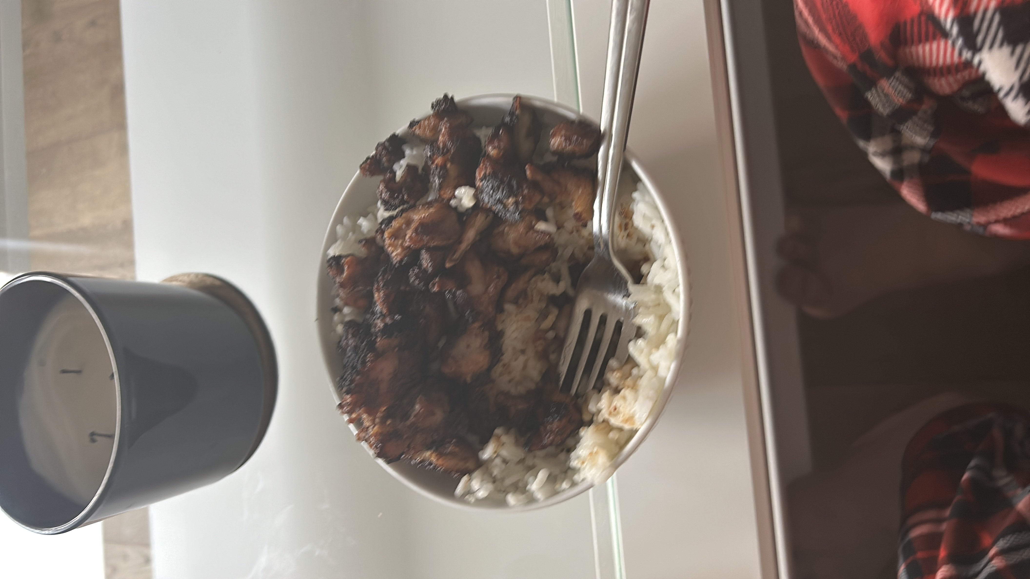 A bowl of white rice topped with grilled chicken, providing a balanced mix of protein and carbohydrates.