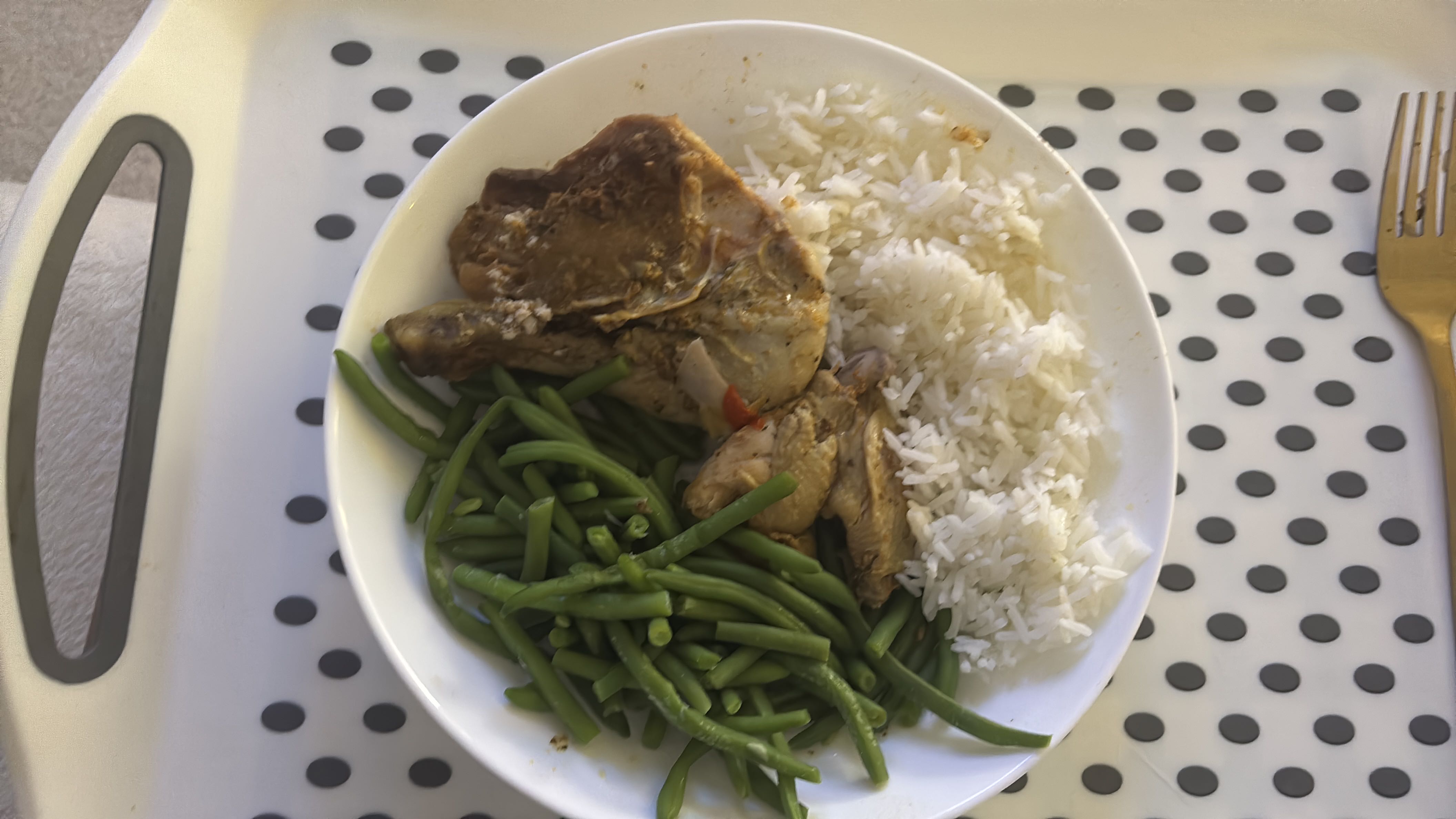 A balanced meal consisting of cooked chicken, white rice, and green beans, providing a good mix of protein, carbohydrates, and fiber.