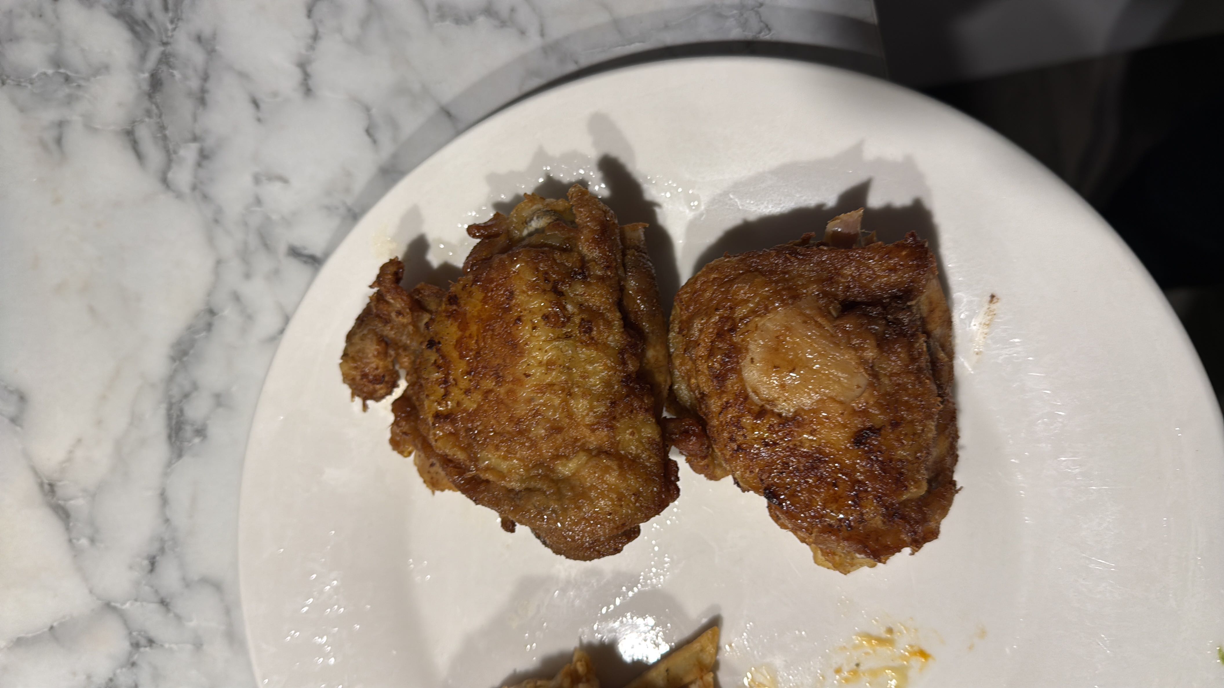 Fried chicken thighs with a crispy golden-brown exterior, likely seasoned and cooked in oil.
