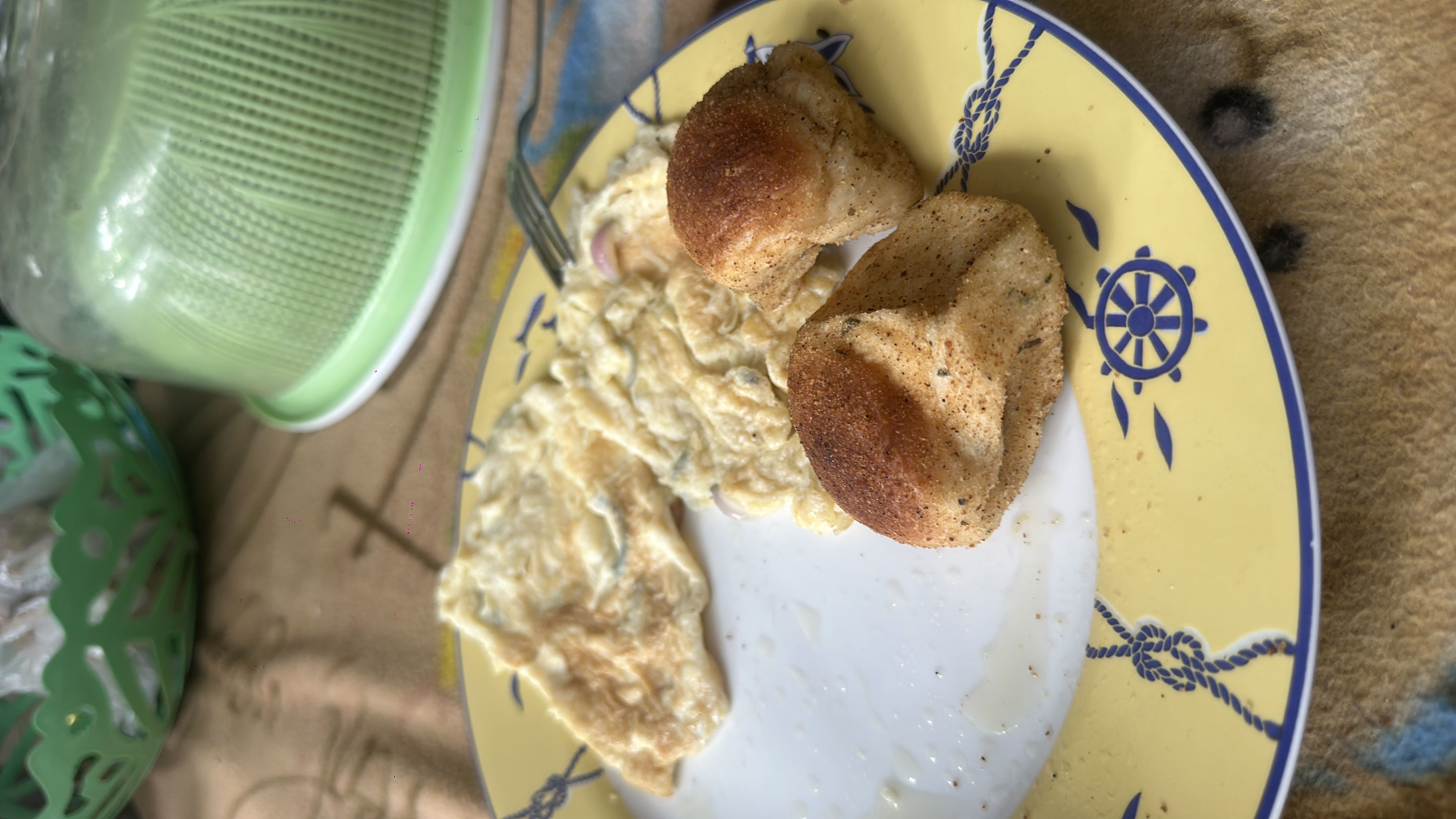 A meal consisting of an omelet with onions and two seasoned bread rolls, providing a balanced mix of protein, carbohydrates, and fats.