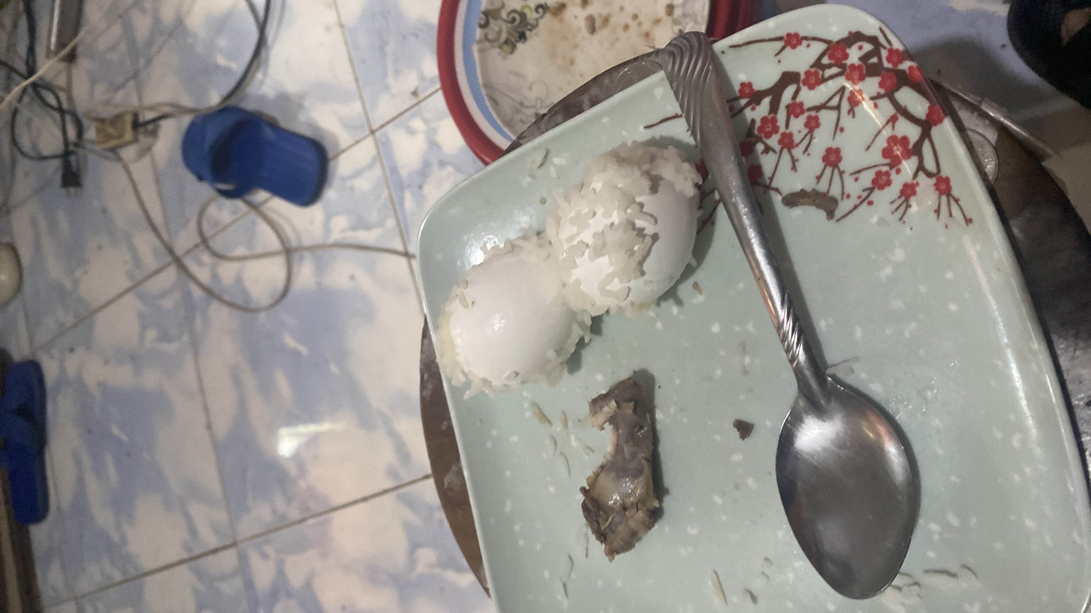 A simple meal consisting of two boiled eggs, white rice, and a small piece of meat, providing a balanced mix of protein, carbohydrates, and fats.