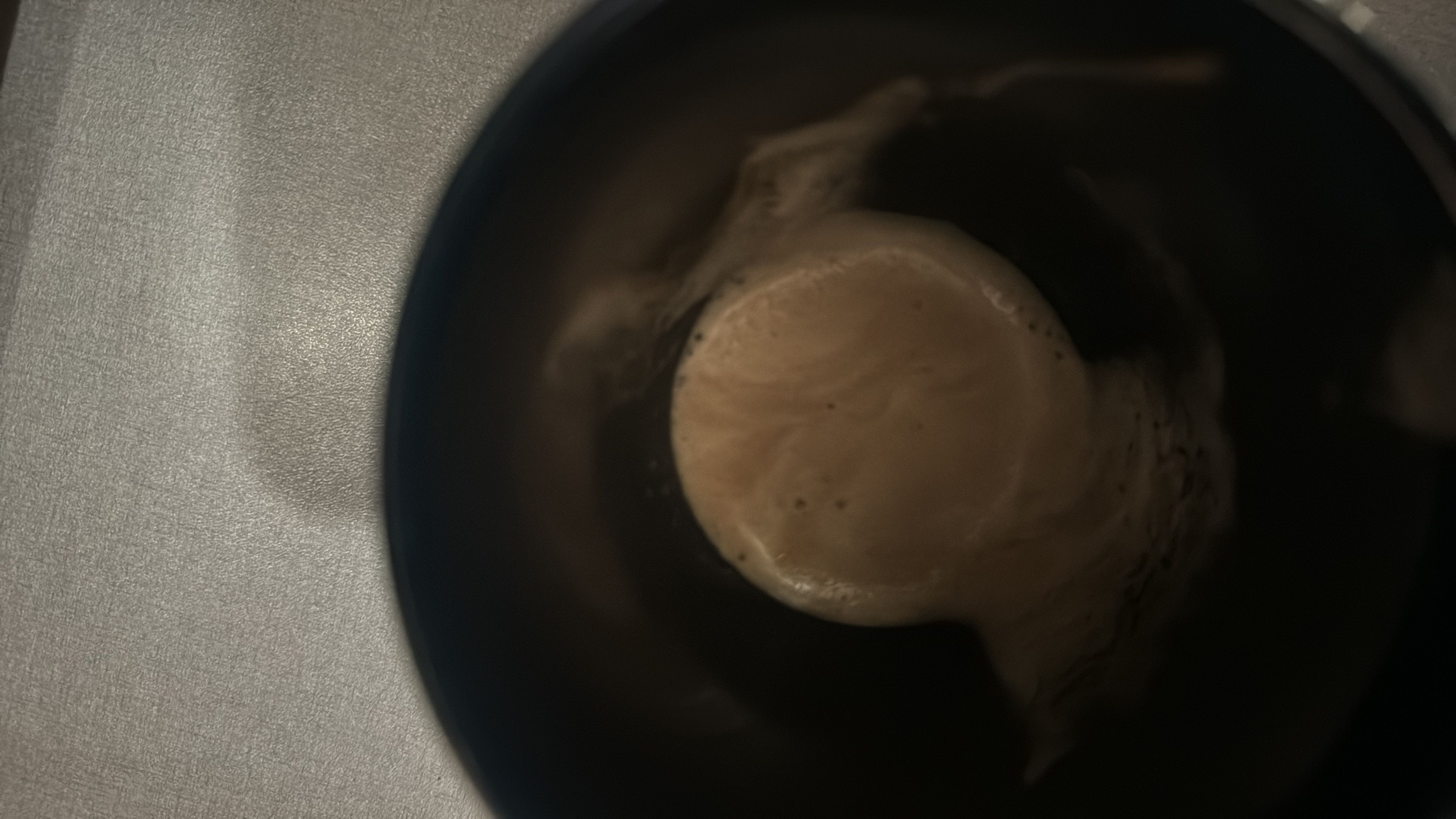 A cup of coffee with milk, featuring a frothy texture and moderate calorie content.