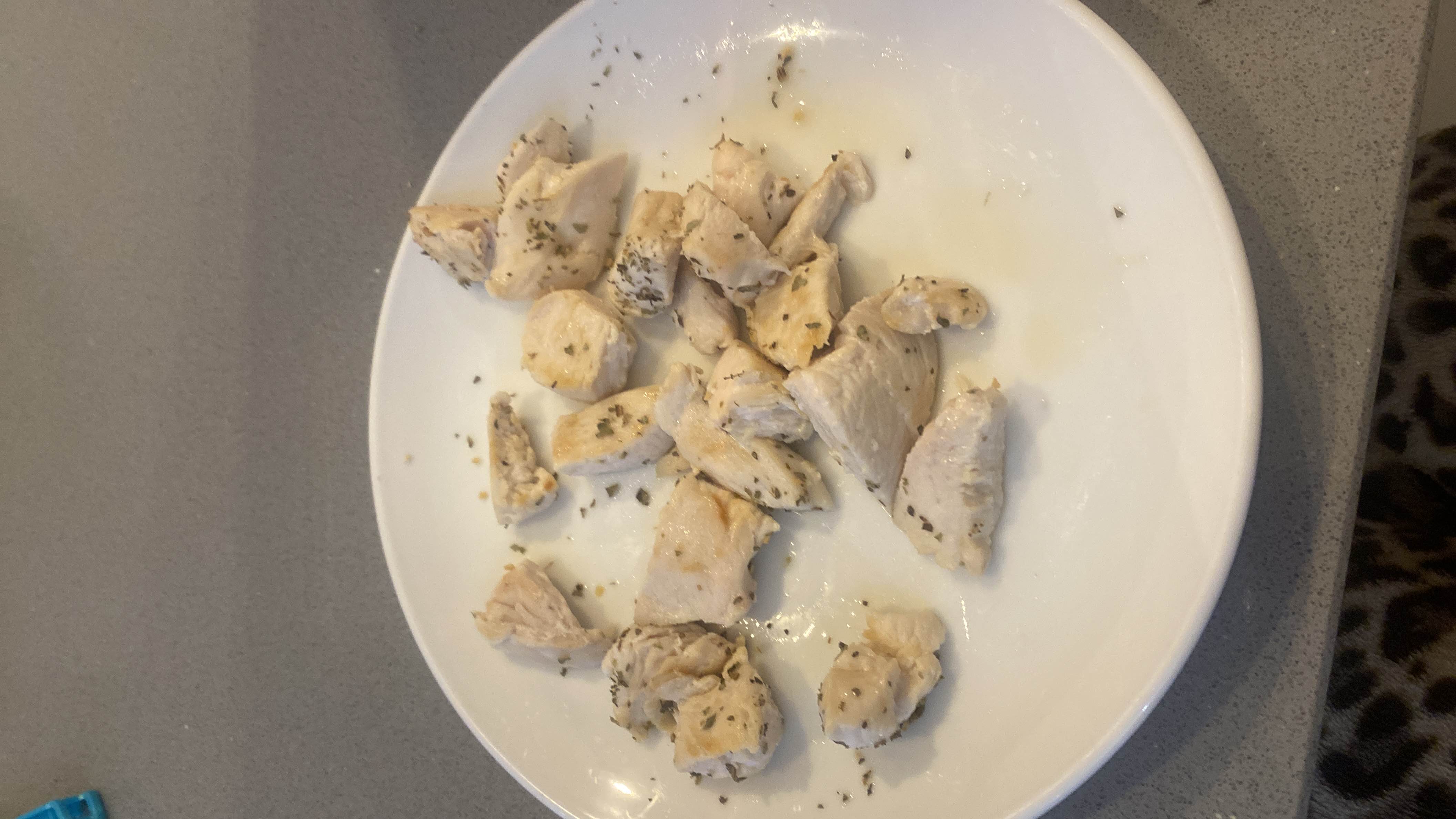 A plate of cooked, seasoned chicken breast cut into bite-sized pieces, providing a high-protein, low-carb meal.