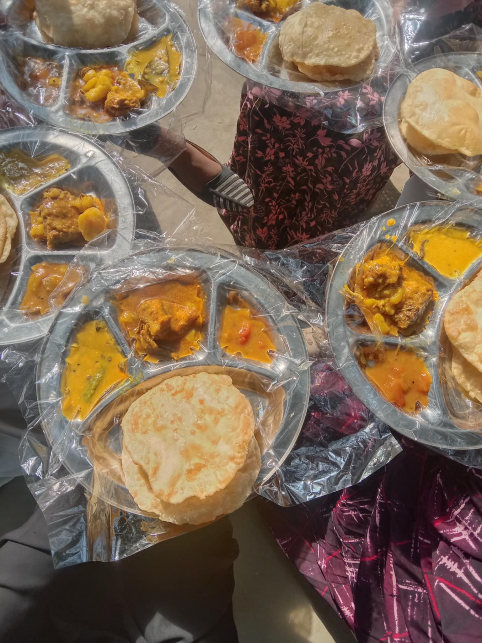 A traditional Indian meal consisting of puri, dal, potato curry, and chicken curry, providing a balanced mix of carbohydrates, proteins, and fats.